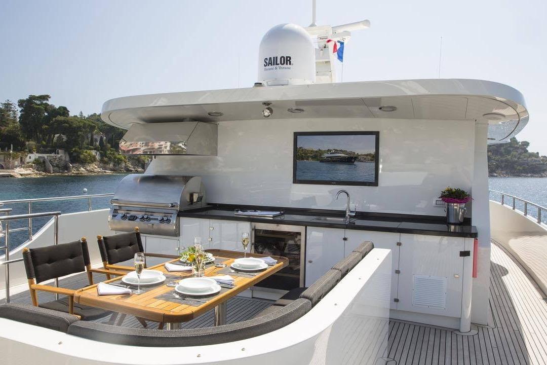 Luxurious outdoor dining area on 2014 Fifth Ocean Yachts 24m Explorer Yacht with scenic ocean view.