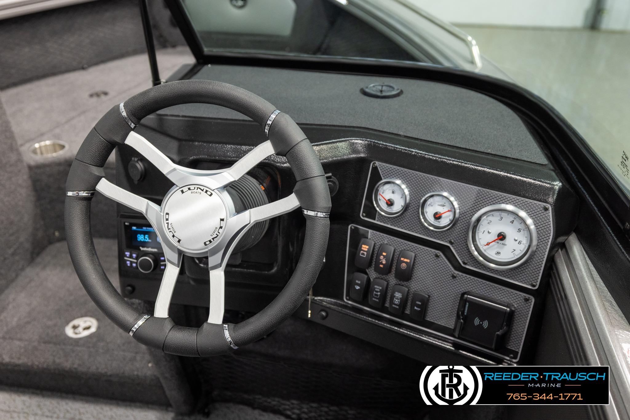 Interior of 2026 Lund 1975 Tyee boat with steering wheel and dashboard controls.