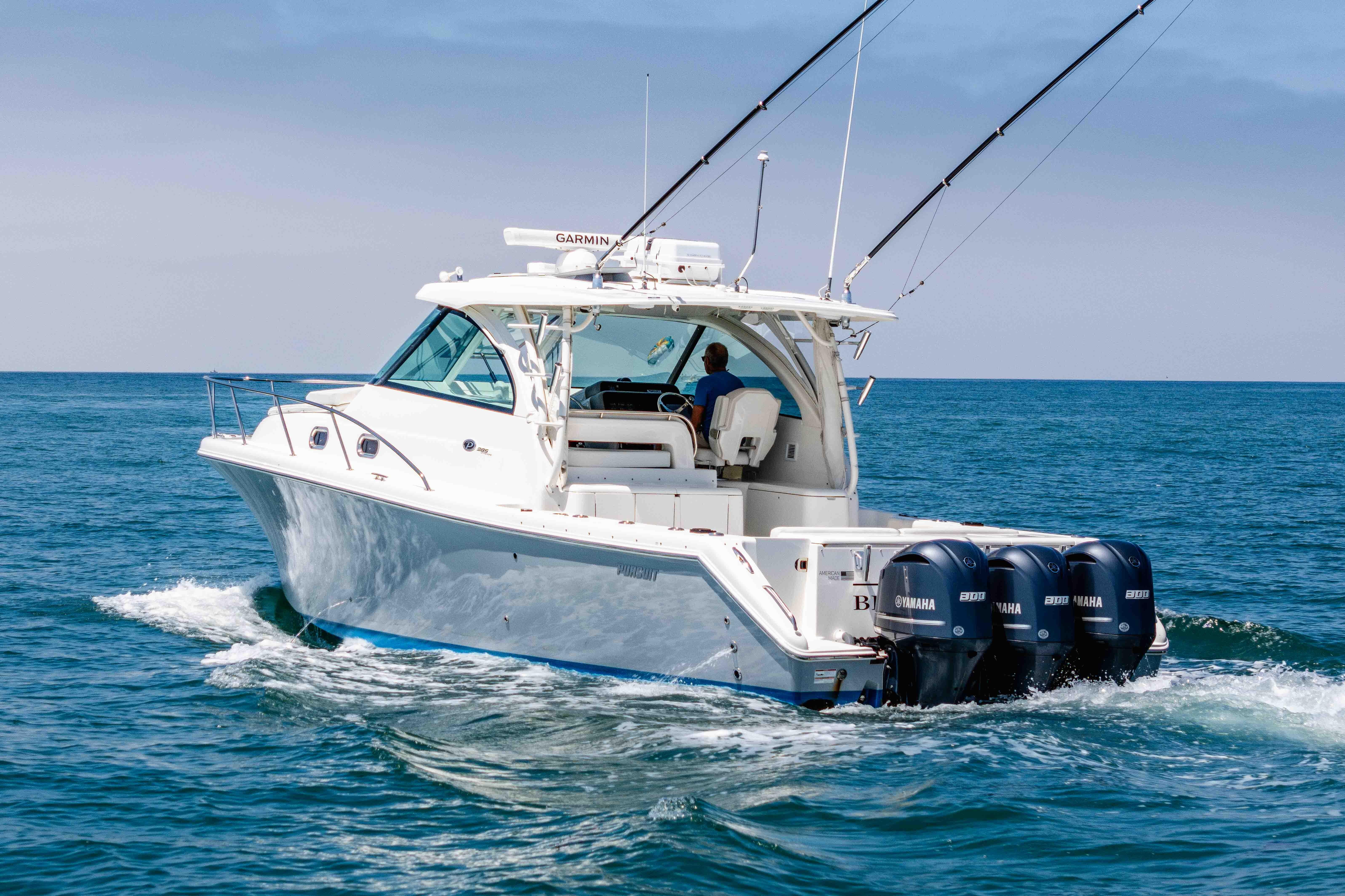 2022 Pursuit OS 385 Offshore boat cruising on open water with triple Yamaha engines.