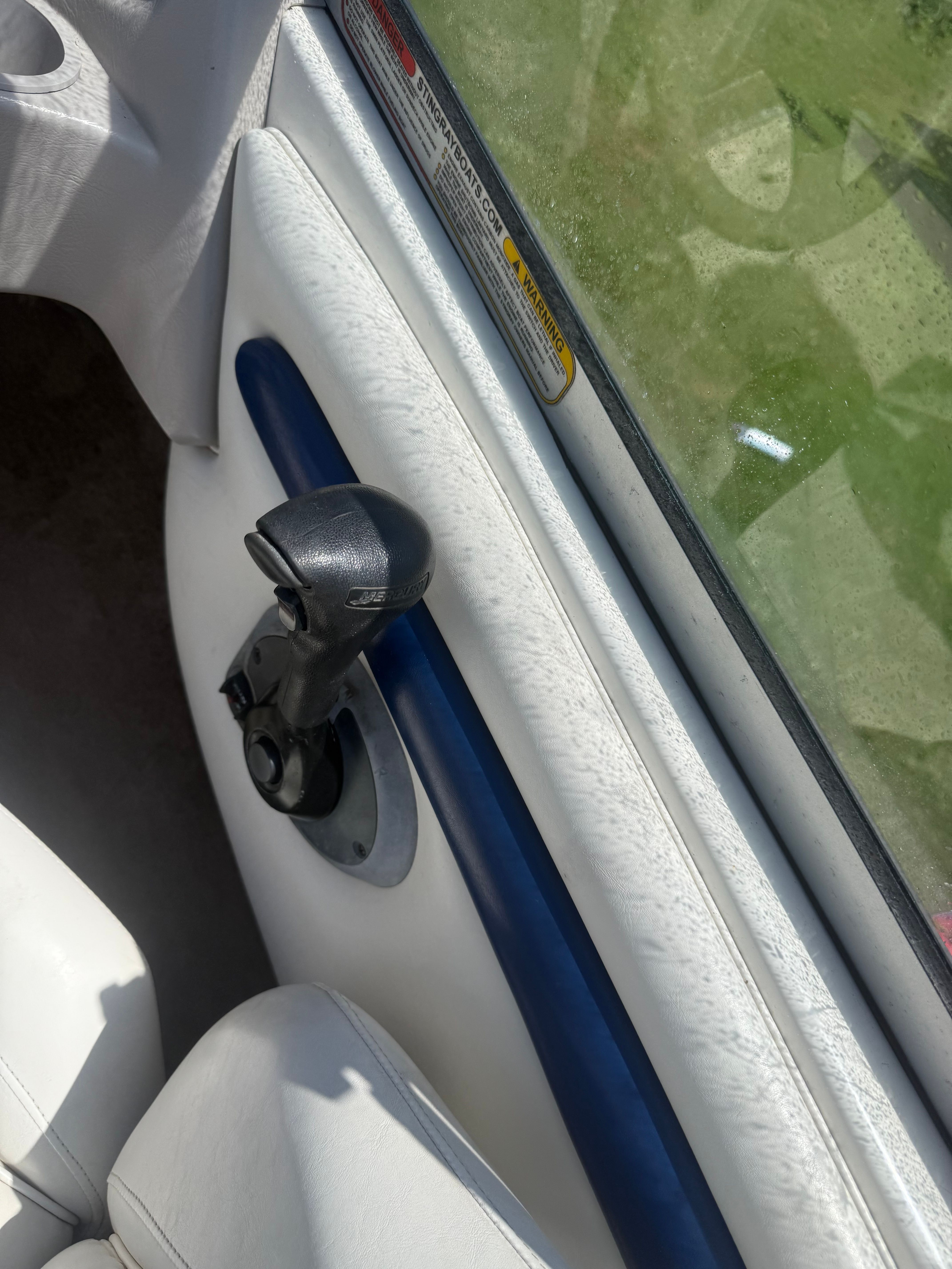 Close-up of a boat interior with white seating and a blue armrest.
