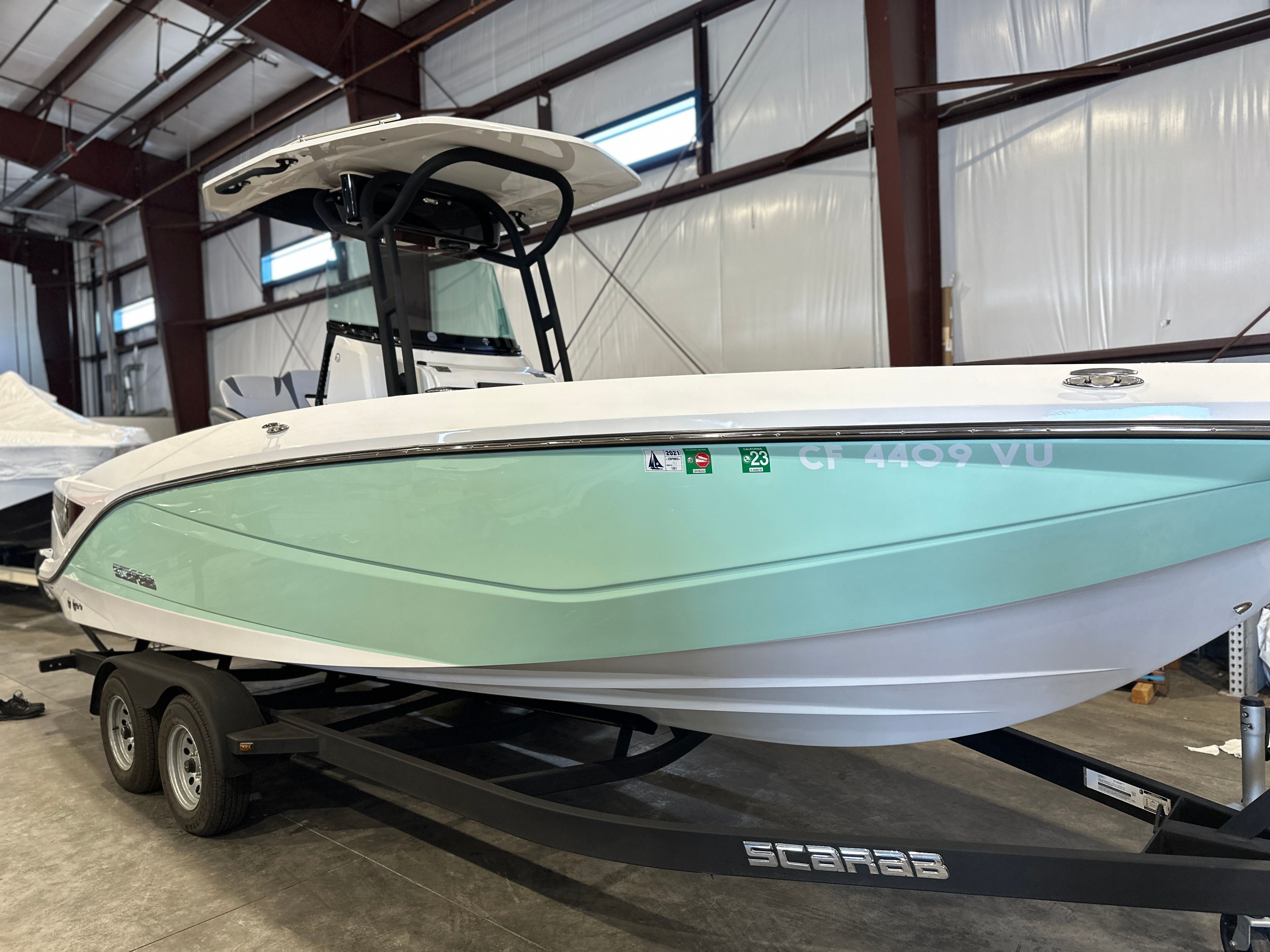 A 2021 Scarab 255 Open ID boat on a trailer inside a warehouse.