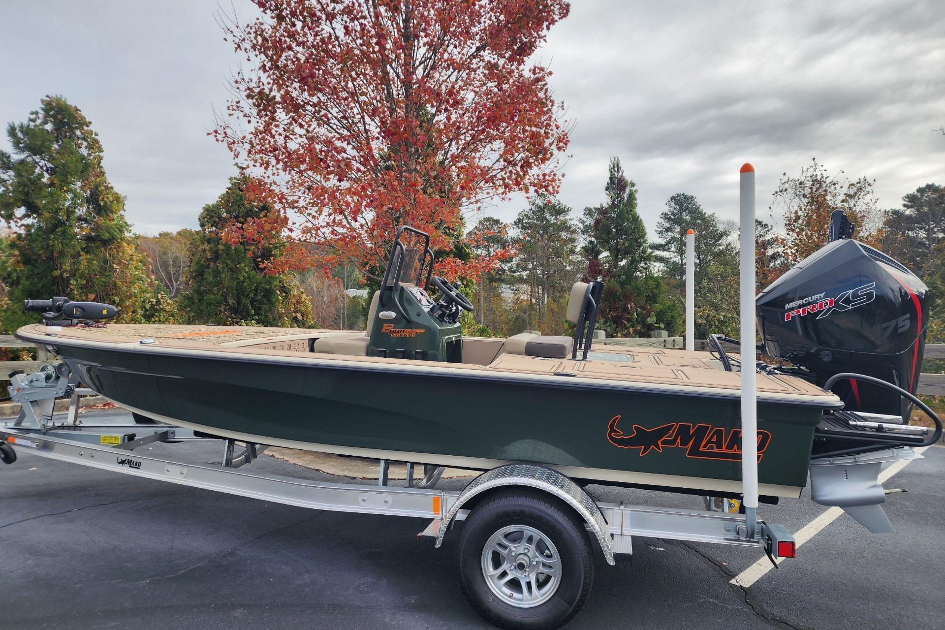 2025 Mako 18 Pro Skiff Backwater Edition on trailer, surrounded by autumn trees.