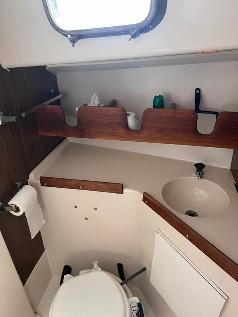Interior of a 1969 Morgan 30 with sink, toilet, and storage shelves.