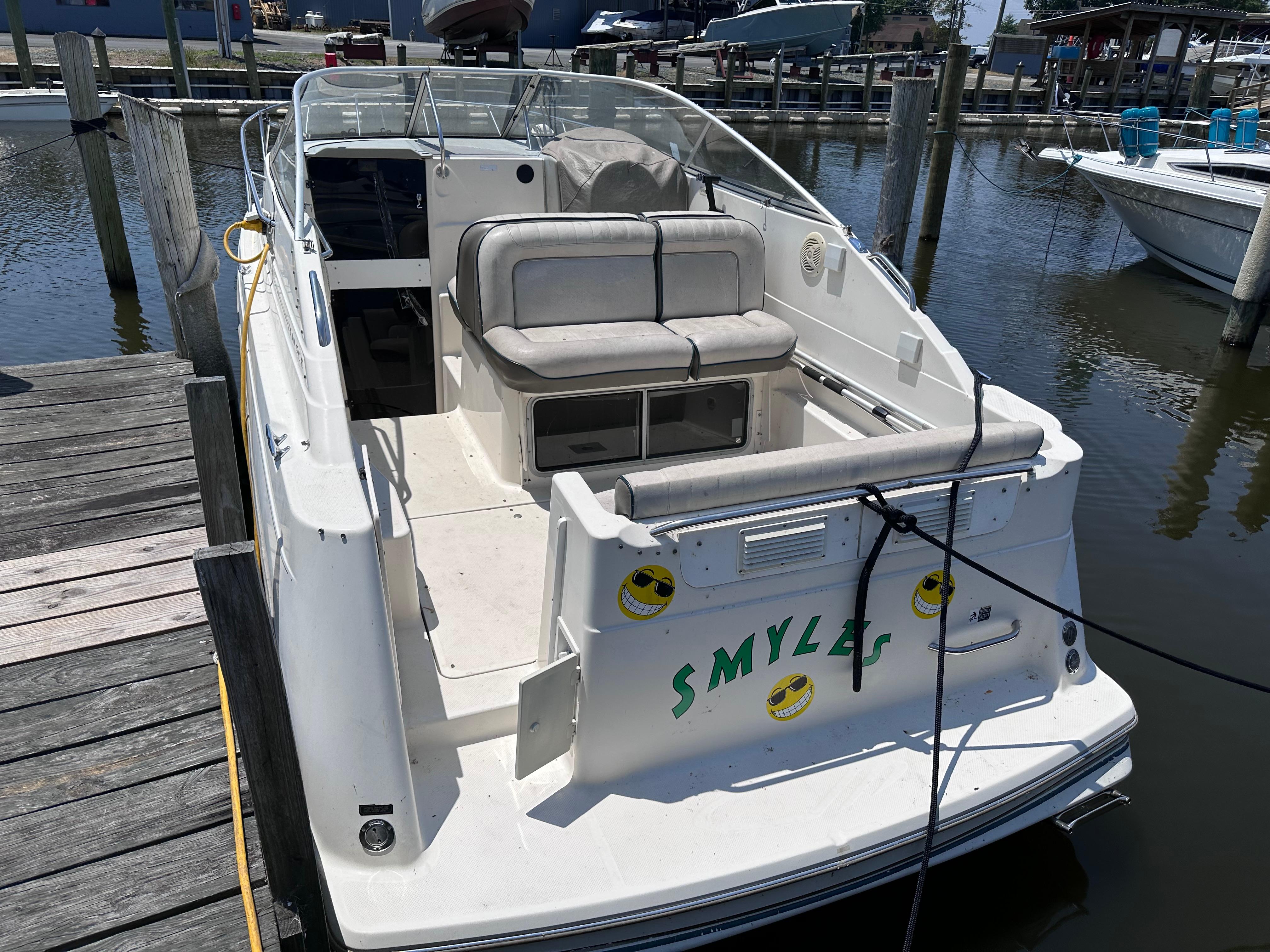 1996 Maxum 2400 SCR boat docked at a marina.