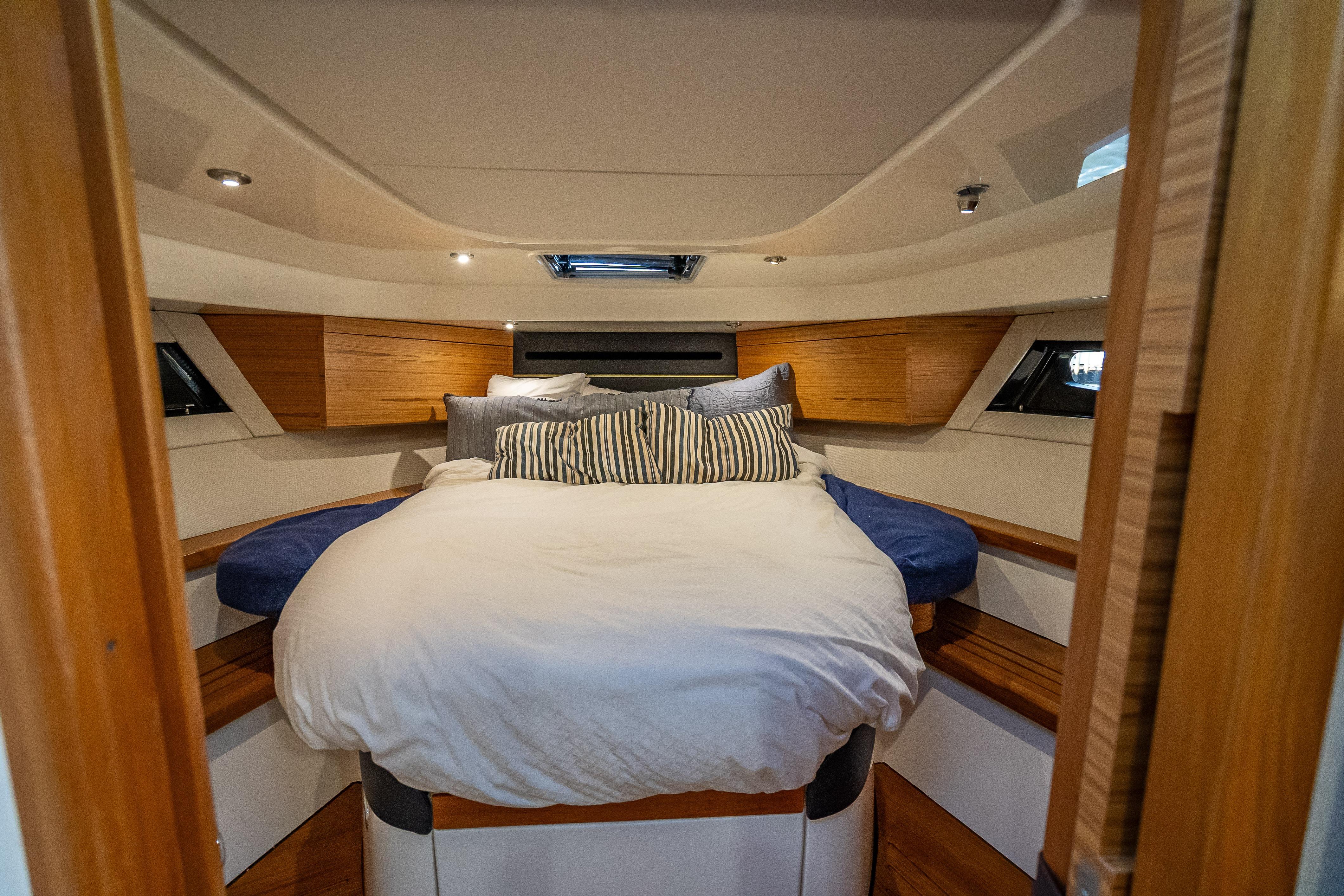 Luxurious cabin interior of 2021 Boston Whaler 405 Conquest with cozy bedding.