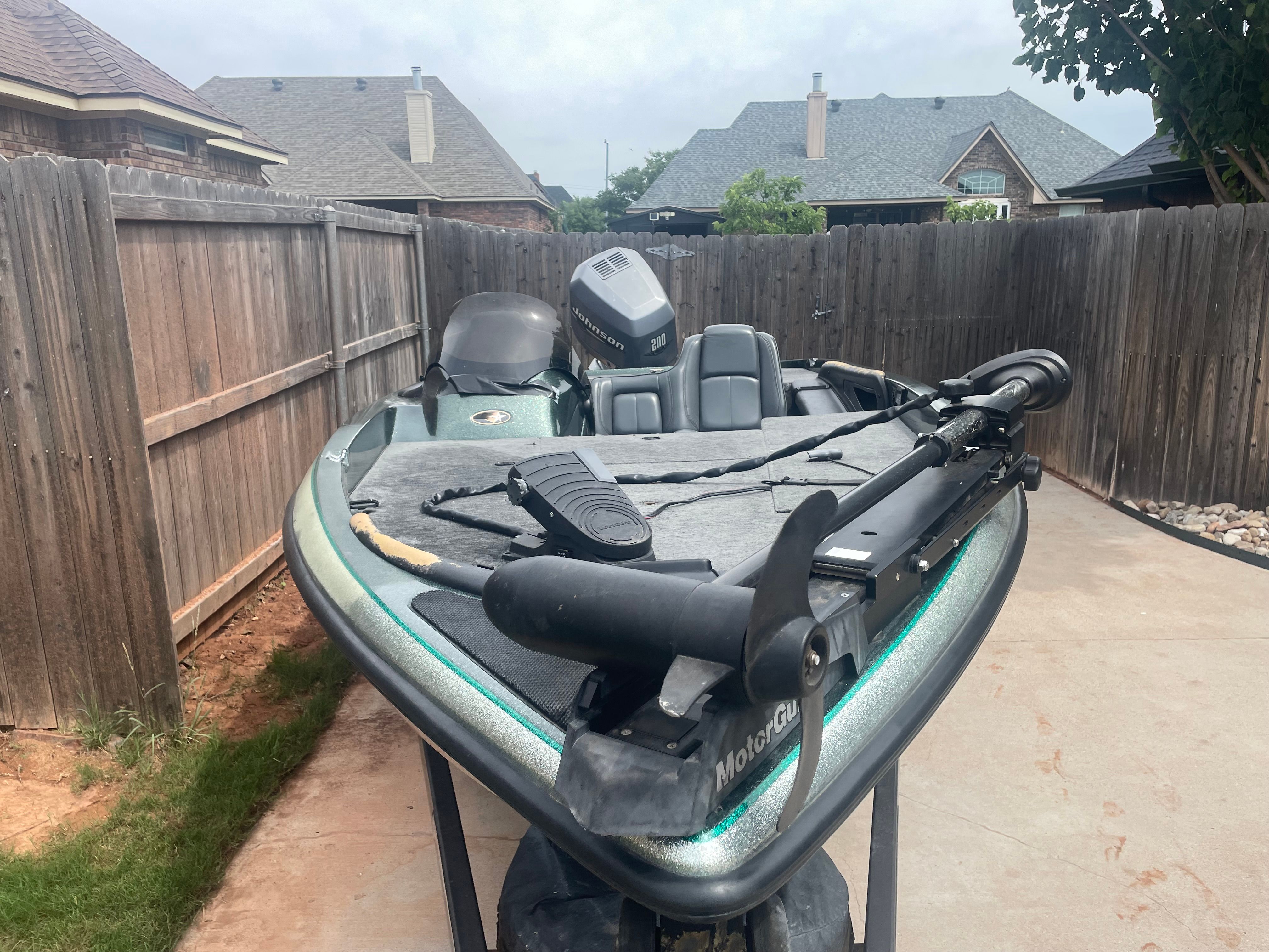 A 2000 Stratos 19 SS boat is in a fenced yard. It features an outboard motor.