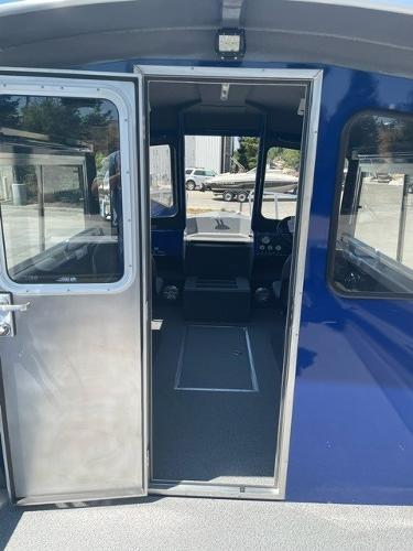 2025 Spartan 240 Maximus Pro boat interior with open door, showcasing cockpit and controls.