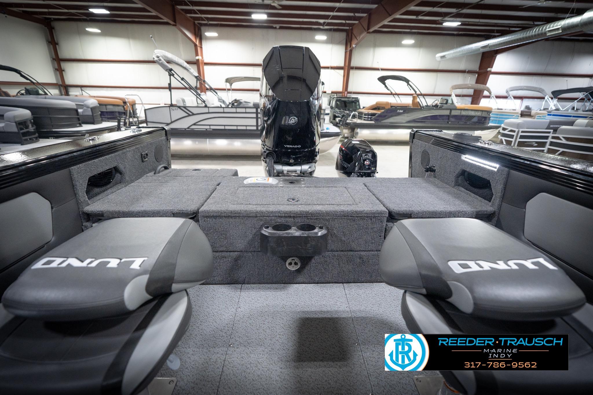 2026 Lund 2275 Baron boat interior with seating and motor in showroom.