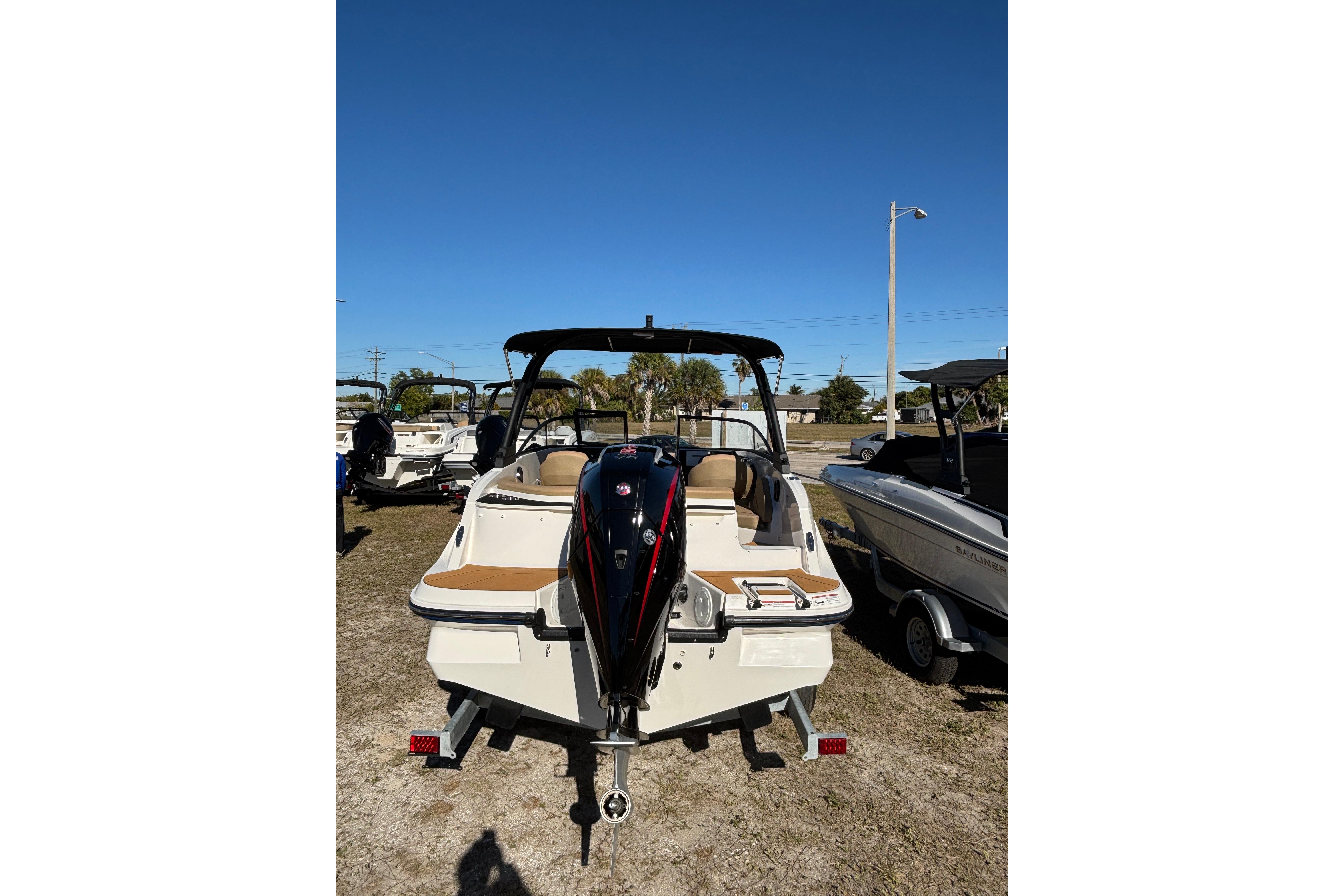 2025 Bayliner V20 boat, rear view, parked on grass under clear blue sky.