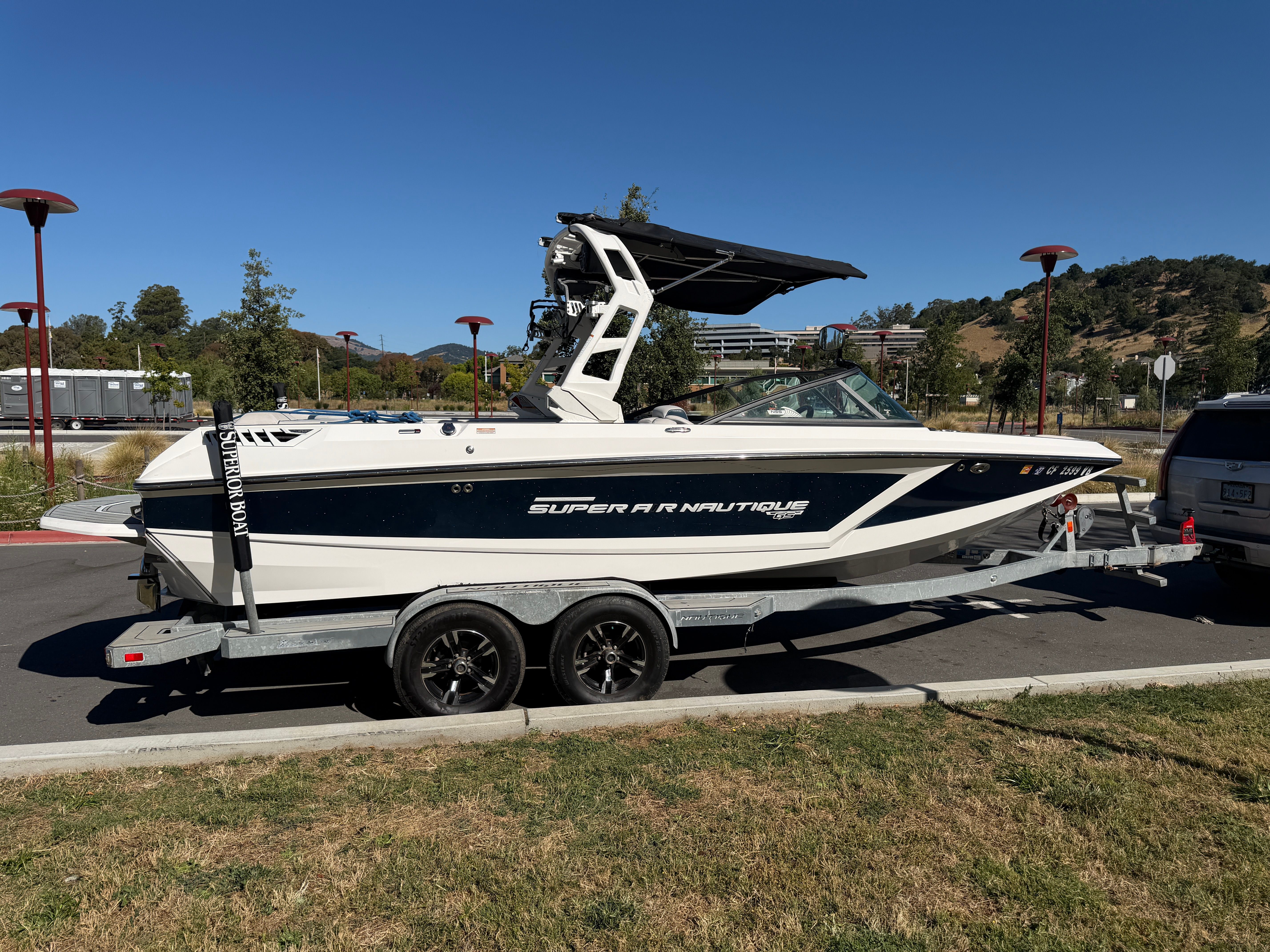 A 2018 Nautique Super Air Nautique GS22 on a trailer, parked in a parking lot.