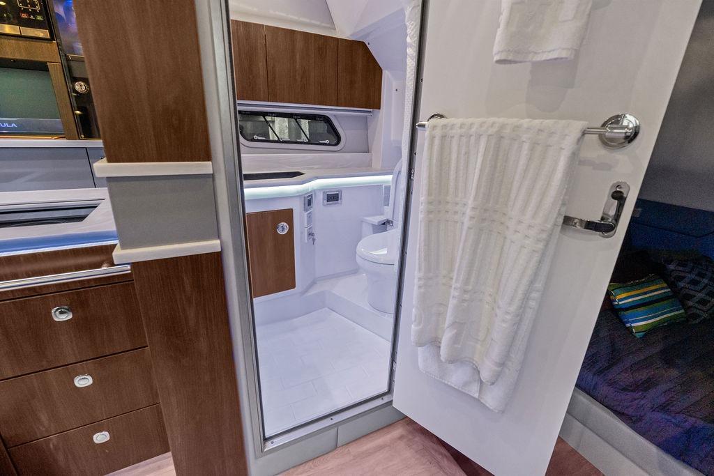 Interior of 2023 Formula 430 Super Sport Crossover, featuring a modern bathroom and wooden cabinetry.