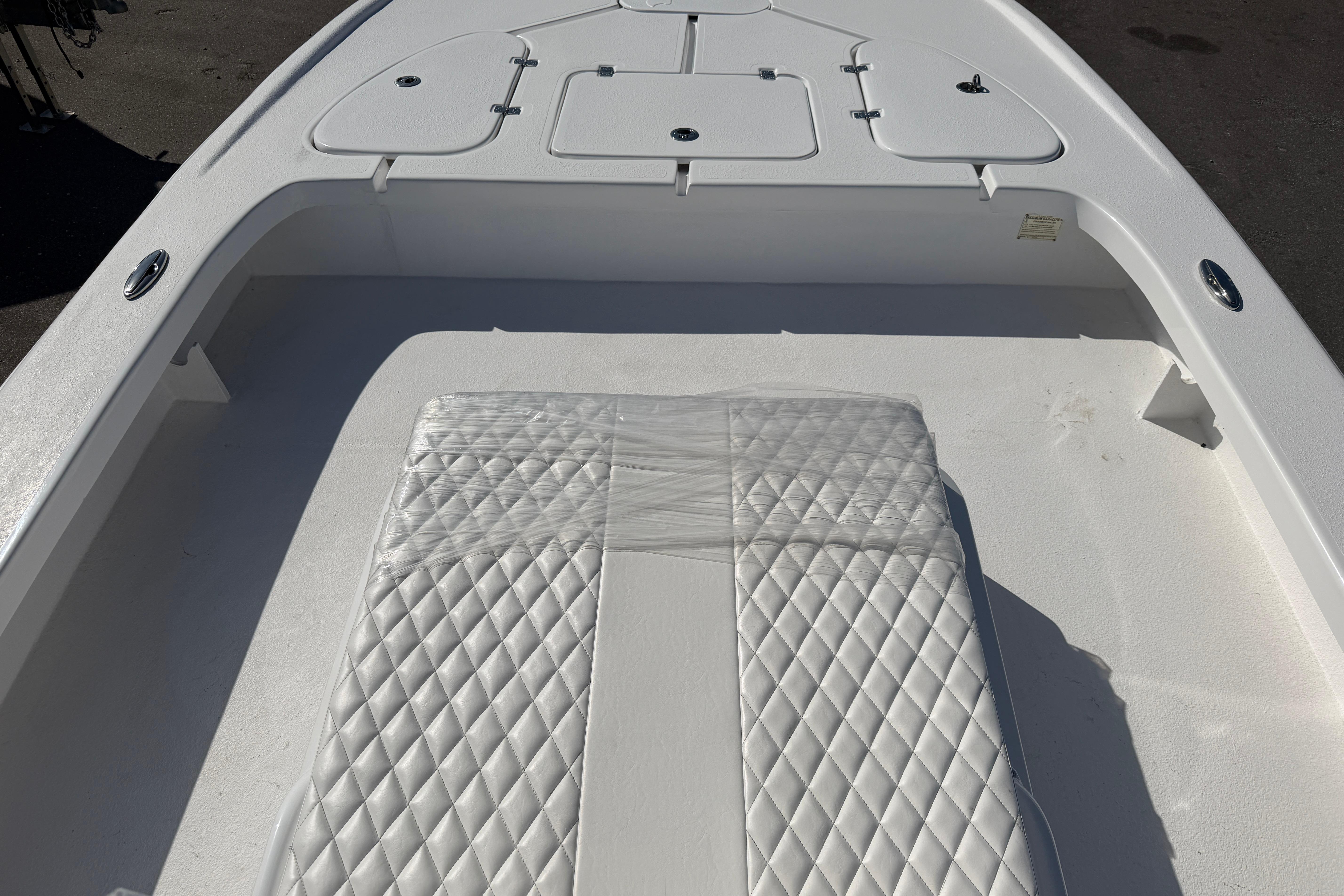 2026 Skuta 24 Cat boat interior with diamond-stitched seating and storage compartments.