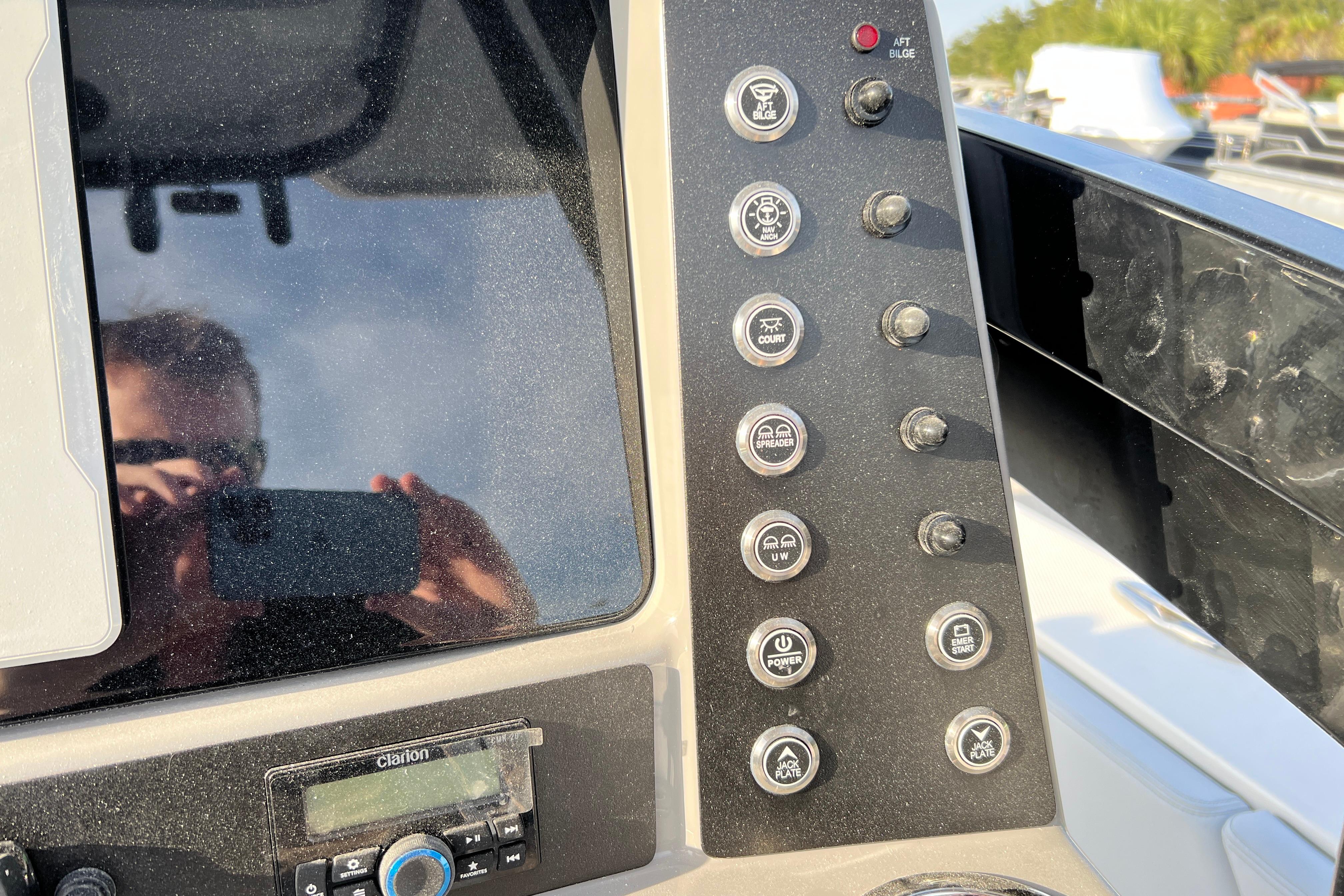 Control panel of 2026 Robalo 246 Cayman boat with various switches and a Clarion audio system.