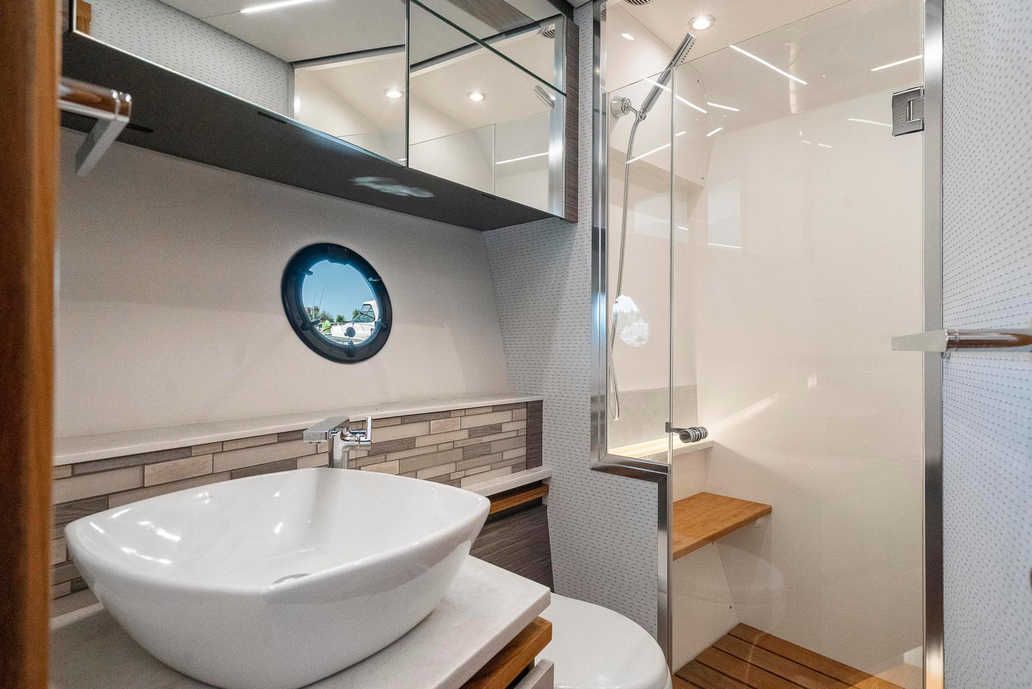 Luxurious bathroom in 2022 Tiara Yachts C49 Coupe with modern sink and shower.