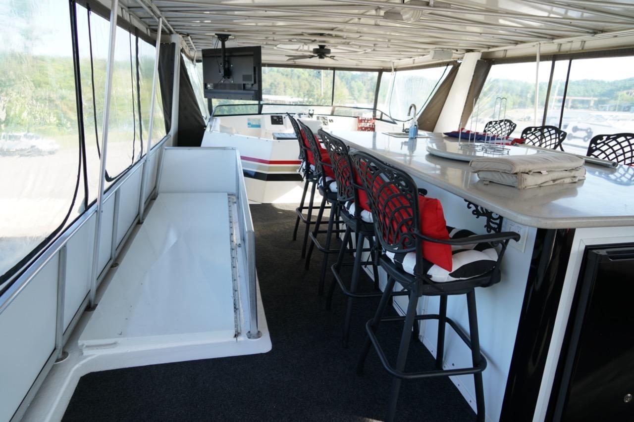 Luxurious 2000 Stardust Cruisers houseboat interior with bar seating and panoramic windows.
