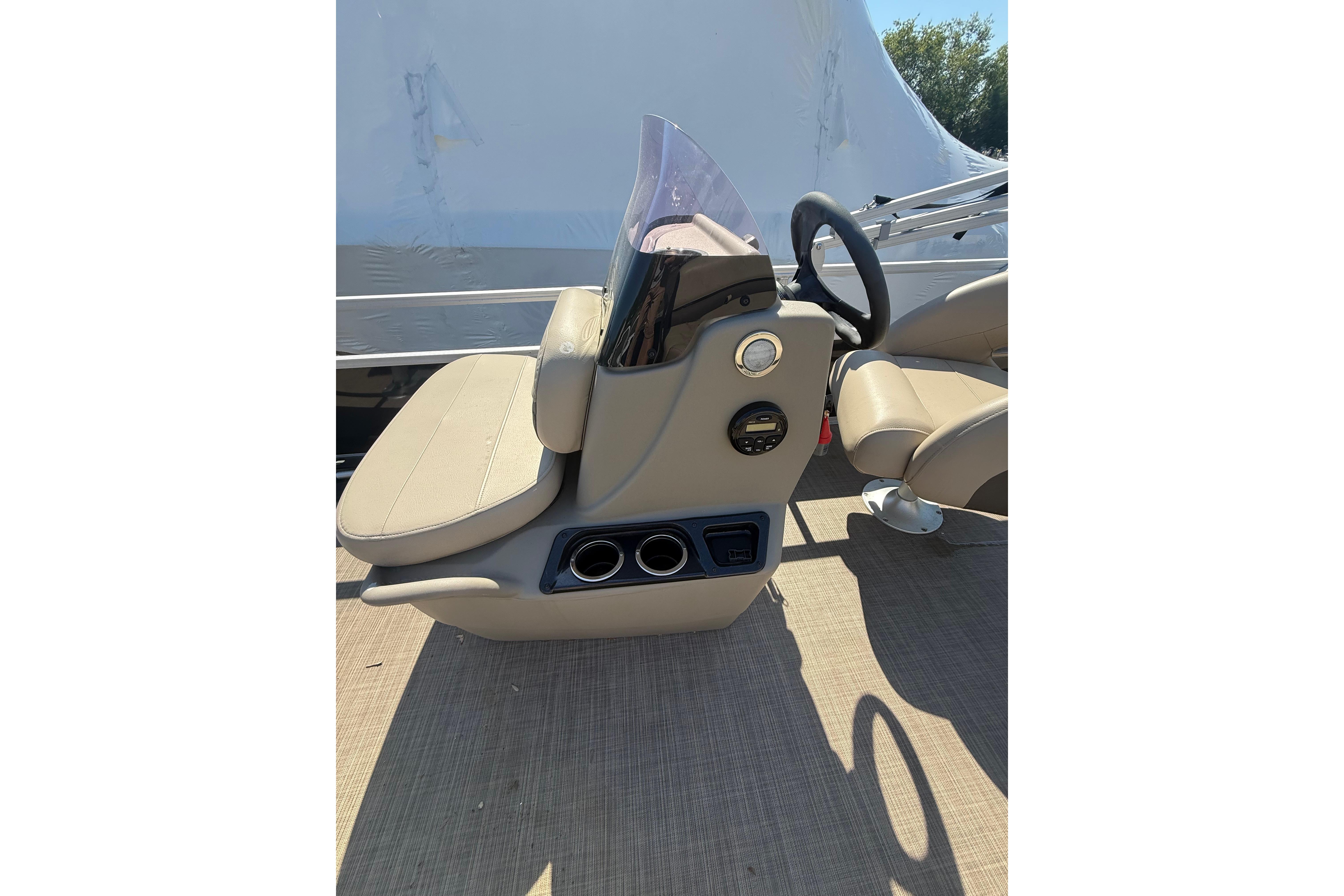 2021 Sun Tracker Bass Buggy 16 XL Select boat console with beige seating and steering wheel.