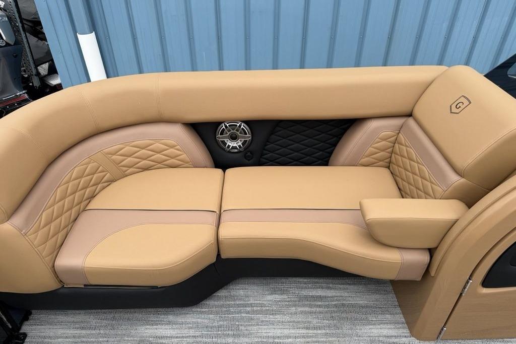 Luxurious tan seating on 2026 Godfrey Monaco 235 SFLC iMPACT boat, featuring quilted design and speaker.