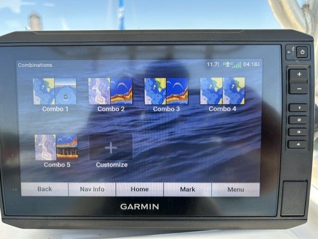 Garmin navigation system on a boat displaying various map combinations on the screen.