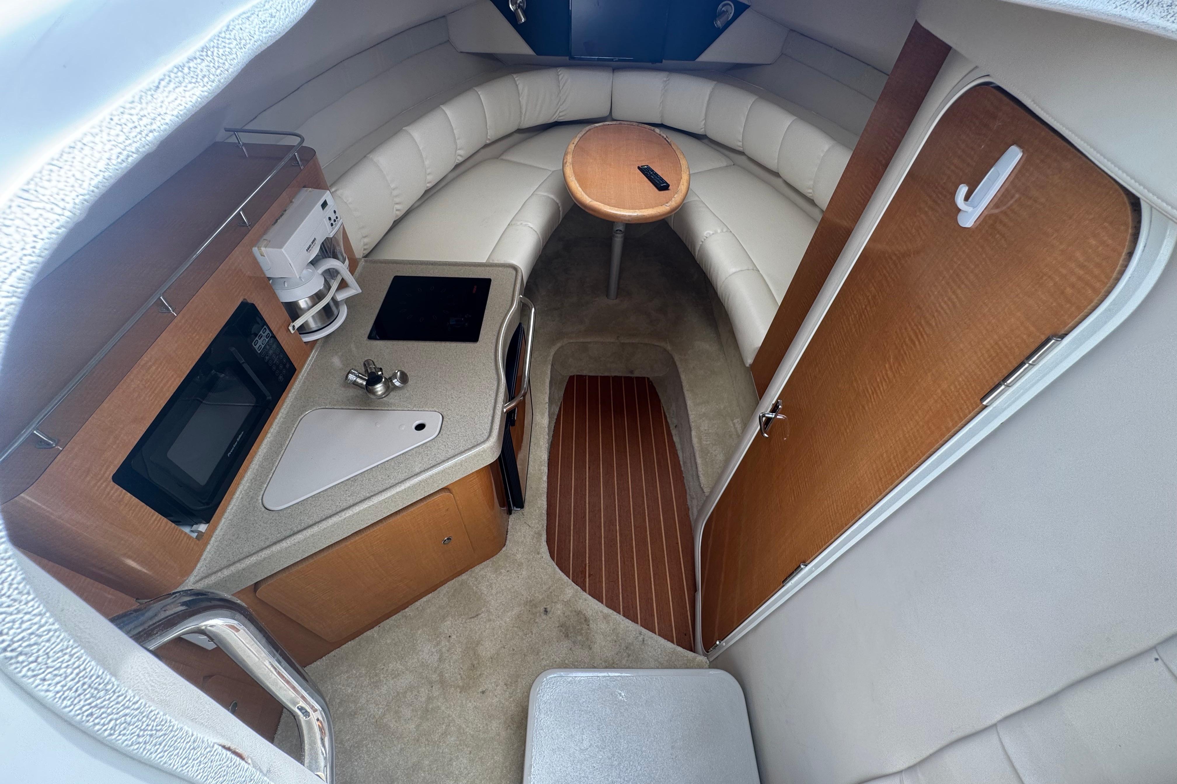 Interior of 2008 Larson Cabrio 260 boat with kitchenette and seating area.