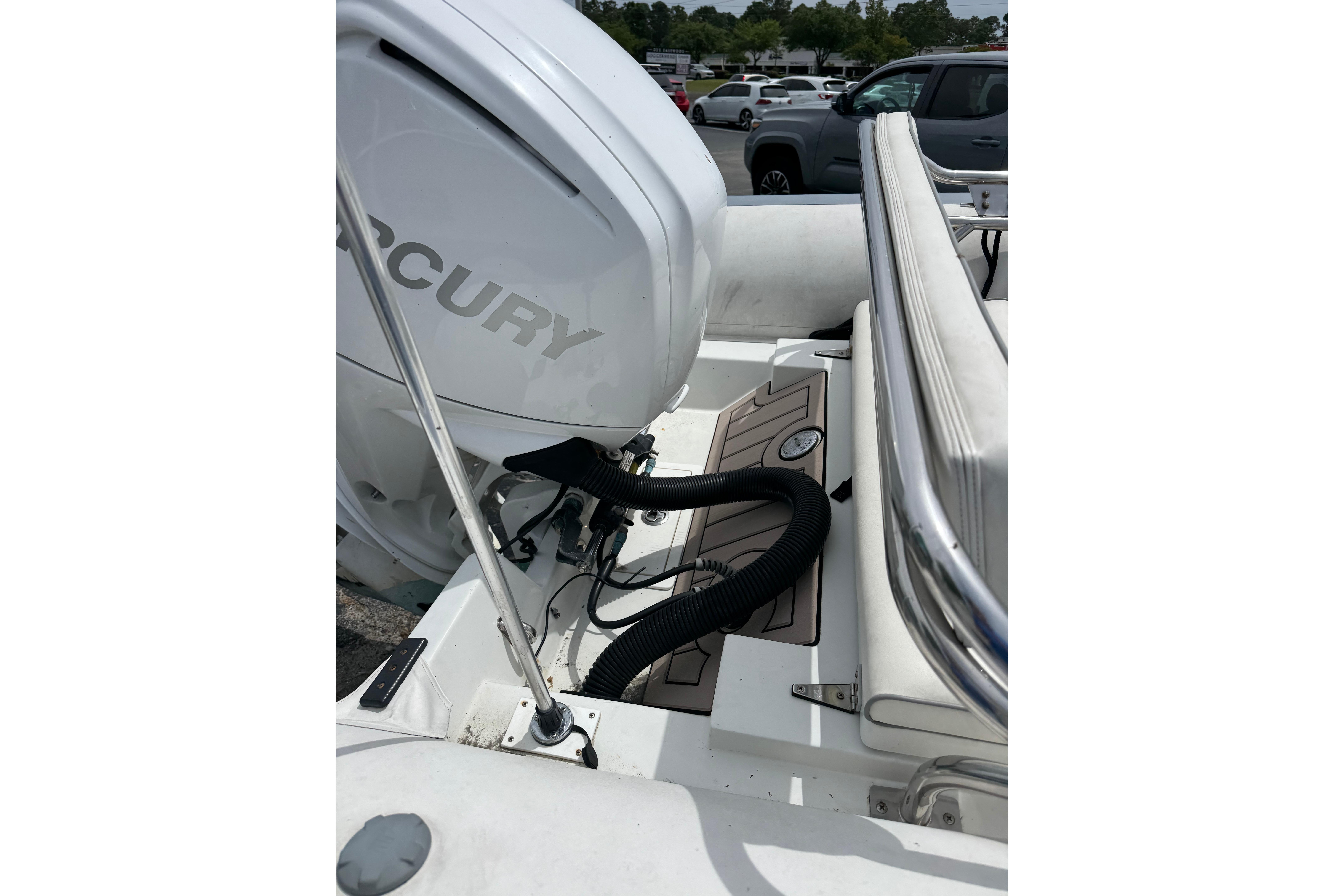 2002 Novurania 17 boat with Mercury outboard engine in a parking lot.