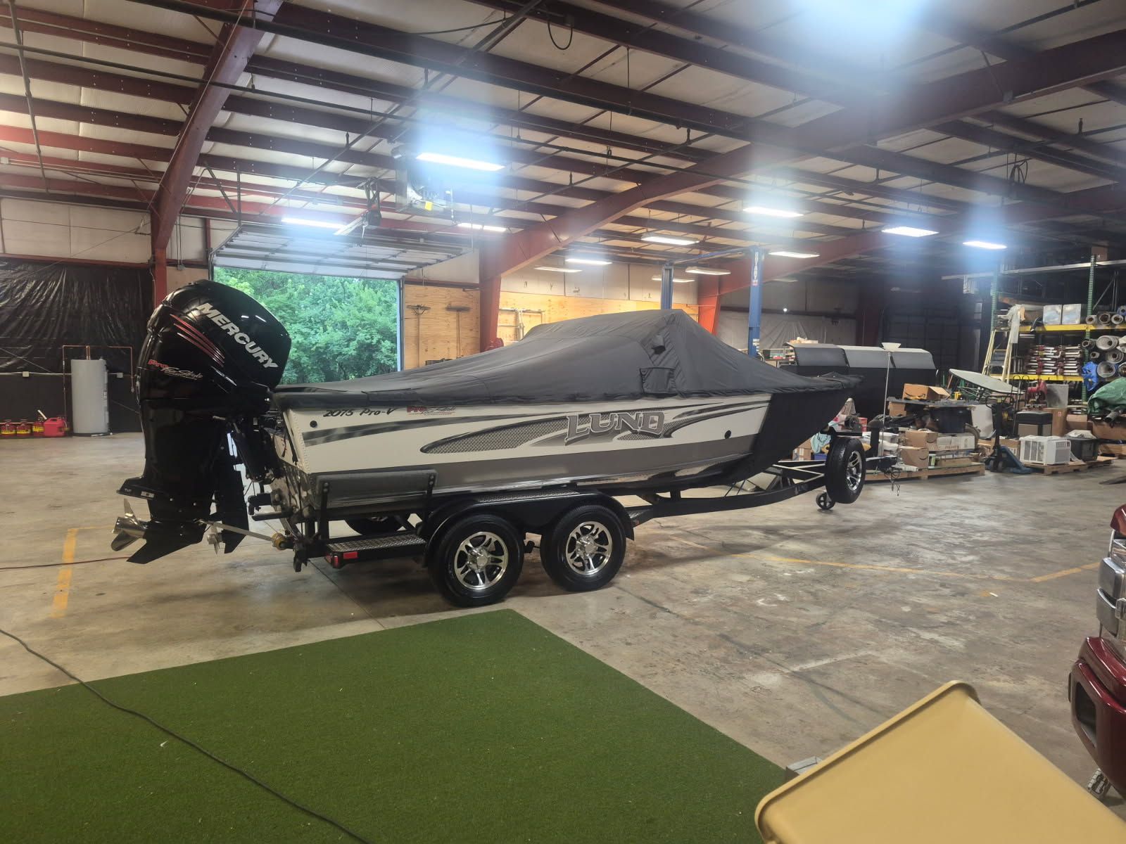 A 2017 Lund Pro-V 2075 boat is on a trailer in a warehouse.