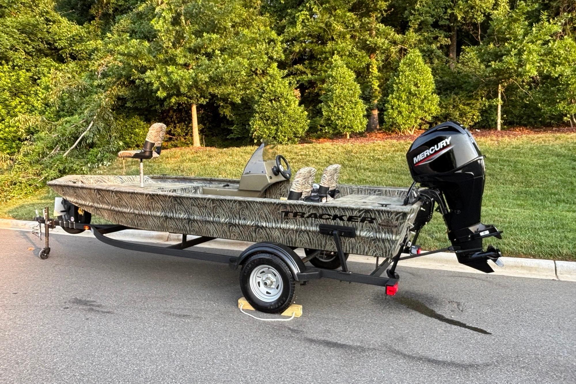 2026 Tracker Grizzly 1754 SC boat with Mercury engine on a trailer, parked outdoors.