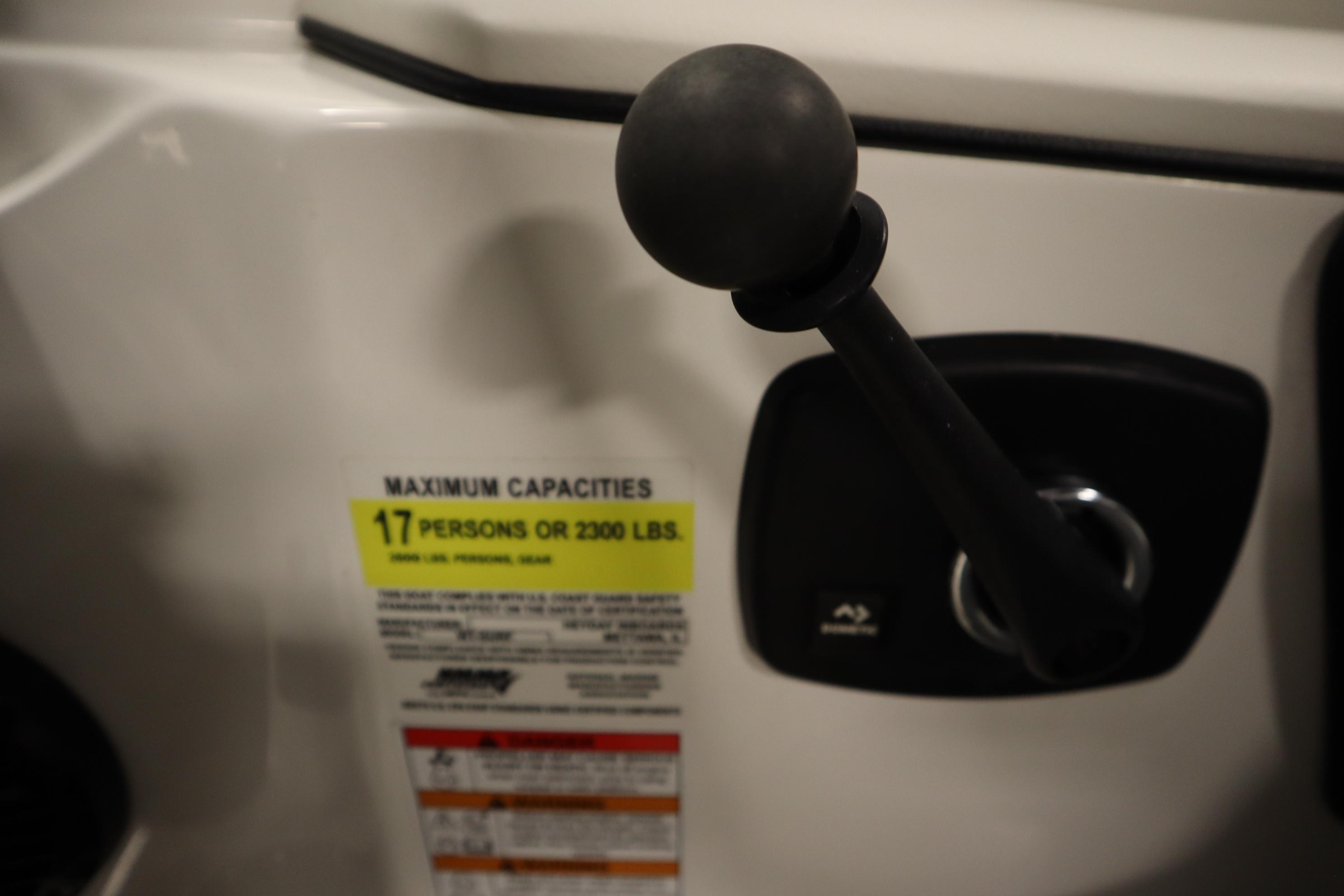 Control lever and capacity label on 2023 Heyday WT Surf boat, indicating 17-person limit.