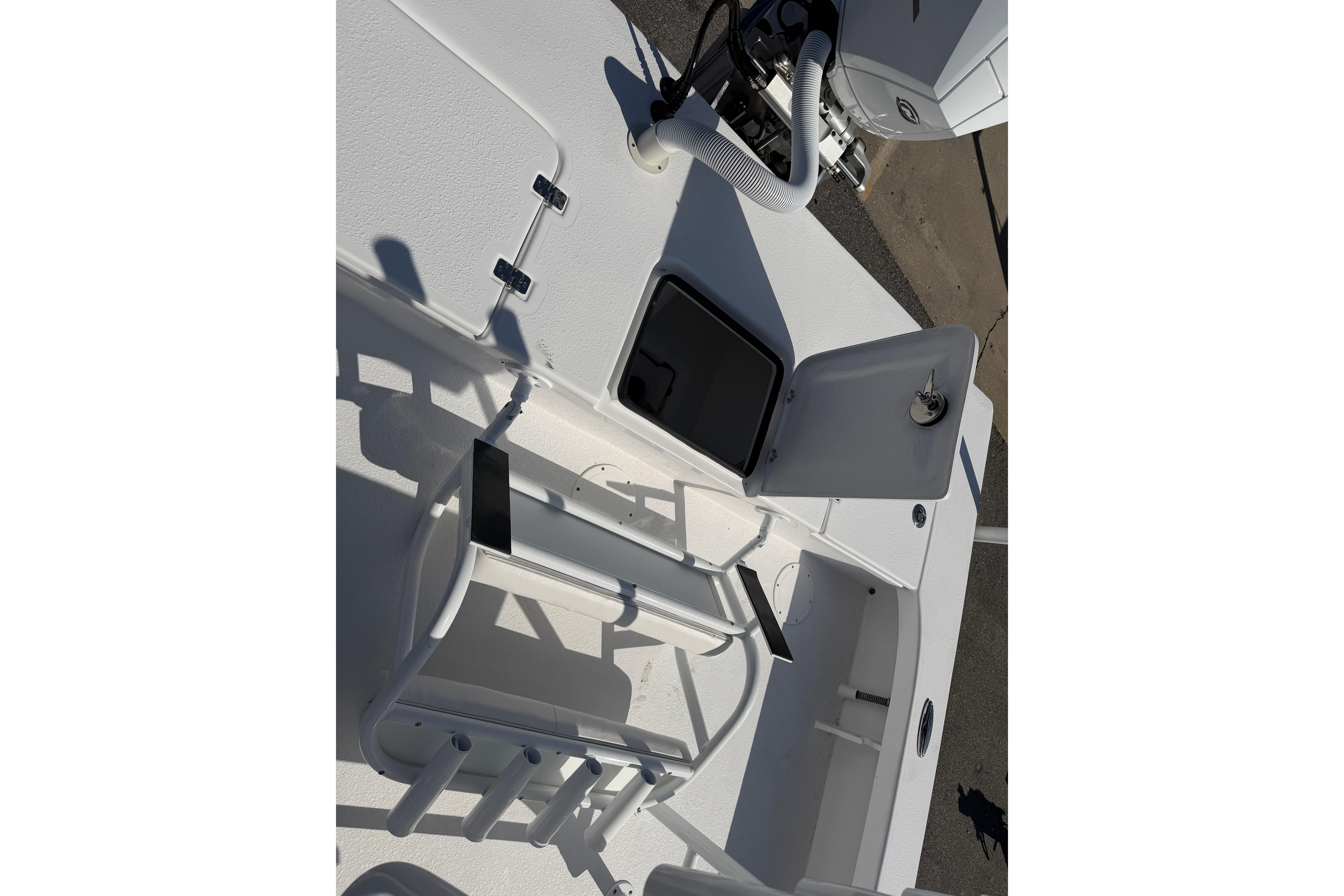 2026 Skuta 24 Cat boat interior with open storage compartments and rod holders.