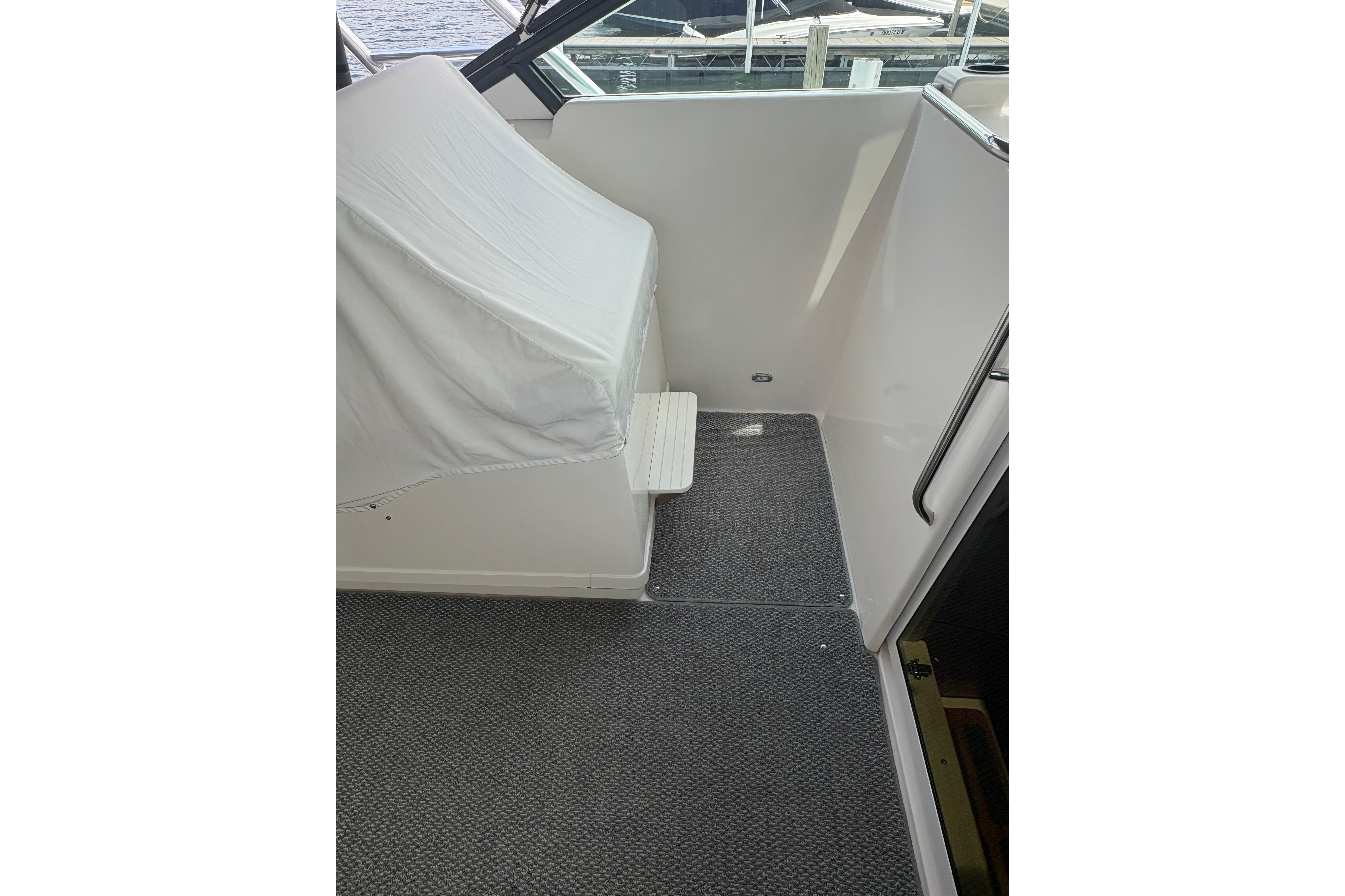 1999 Tiara Yachts 3100 Open interior with covered seating and carpeted flooring.