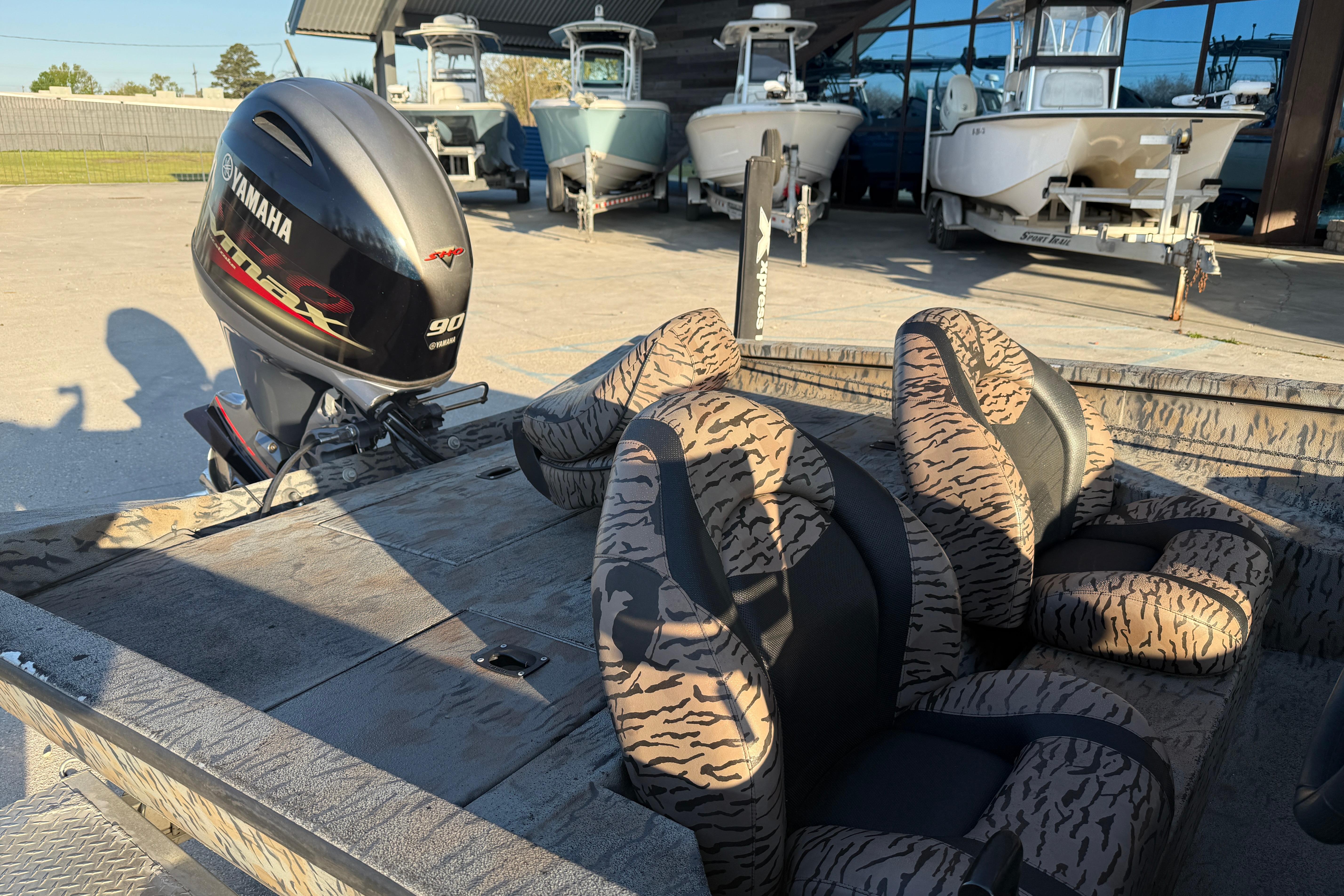 2019 Xpress XP7 boat with Yamaha engine, camo seats, and other boats in the background.