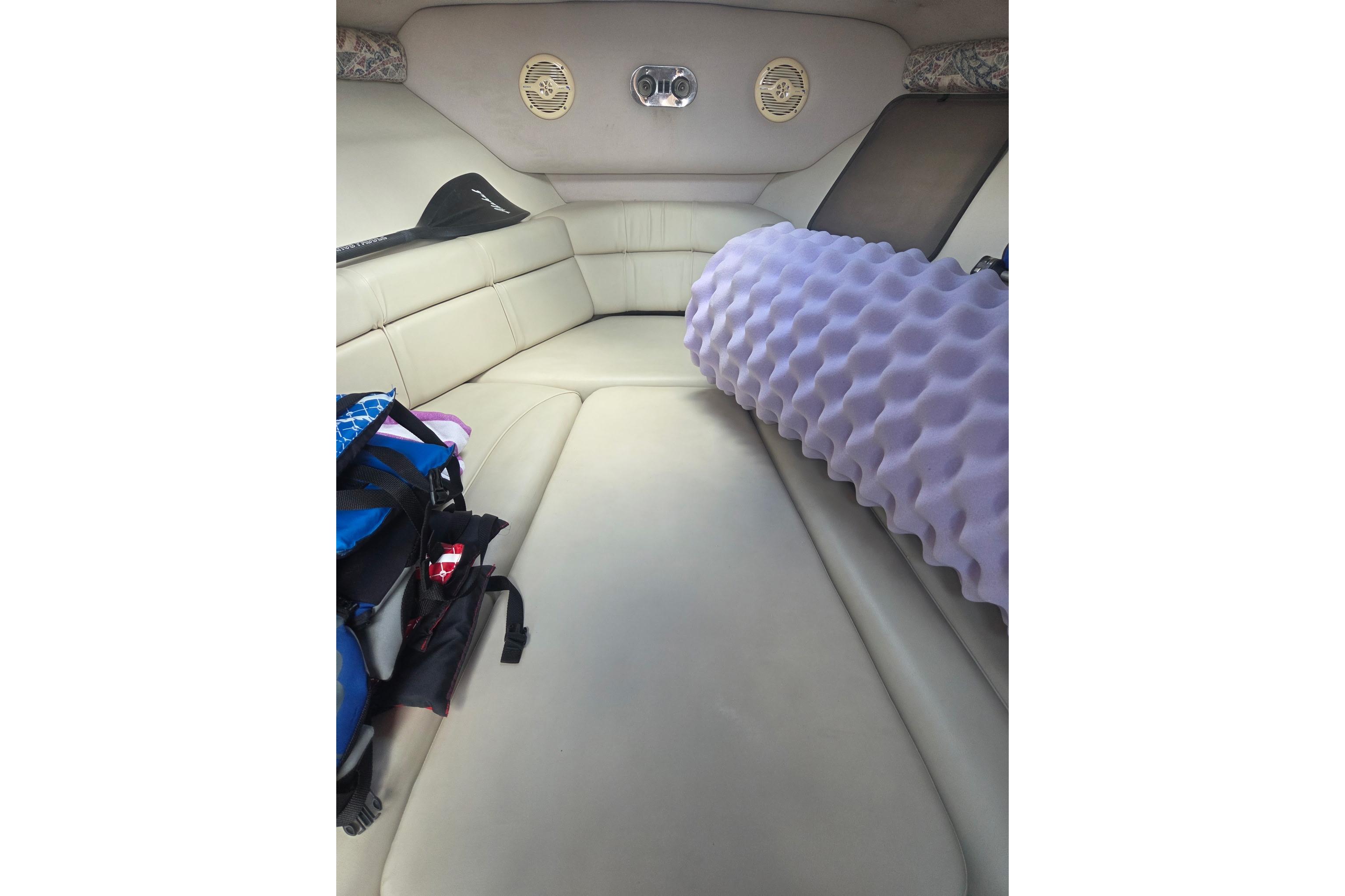 Interior cabin of 2001 Crownline 242 CR boat with seating and purple cushion.
