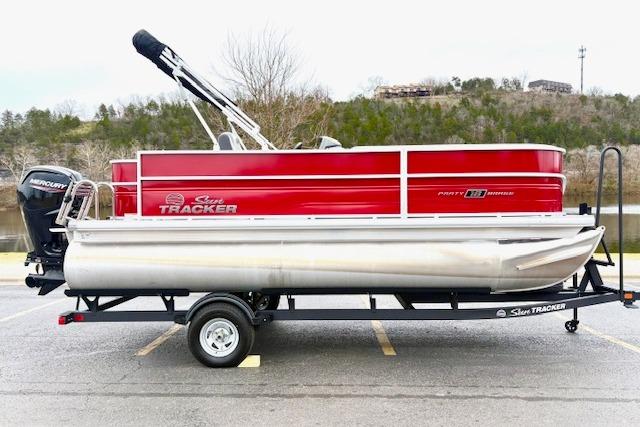 2026 Sun Tracker Party Barge 18 DLX pontoon boat on trailer, red and silver design.