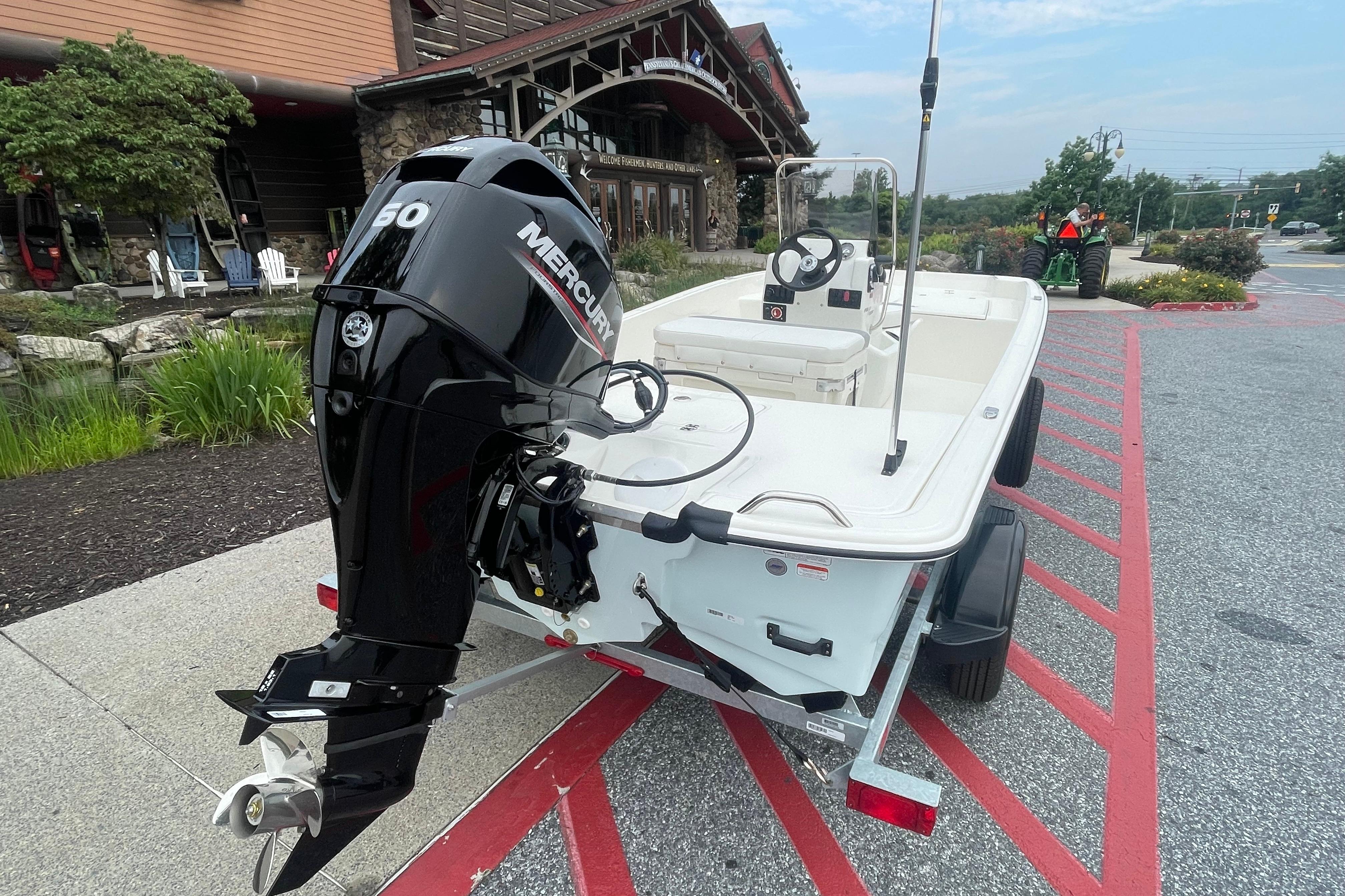 2026 Mako Pro Skiff 17 CC with Mercury engine, parked outdoors near a building.