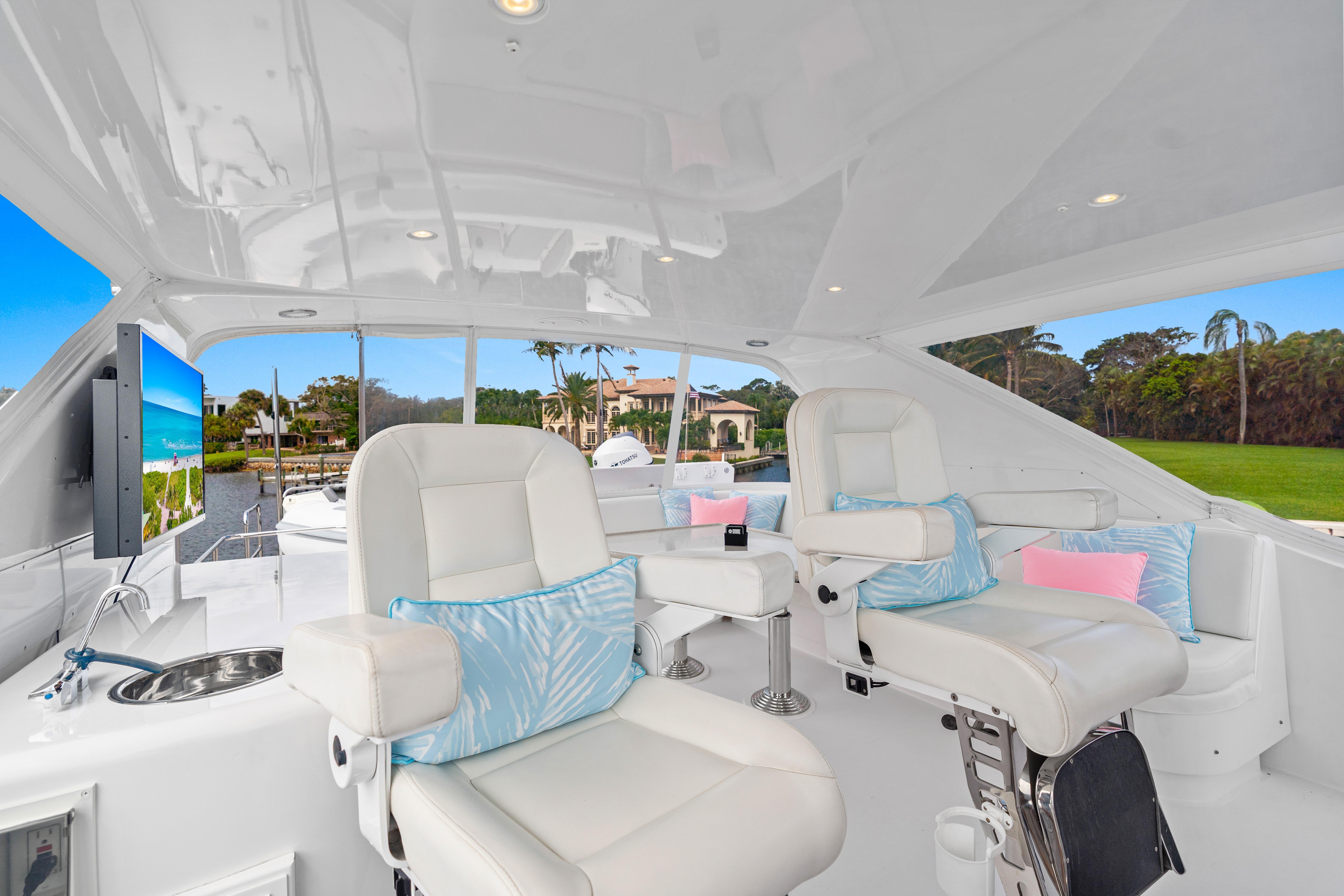 Luxurious interior of 2008 Hatteras 64 Motor Yacht with plush seating and scenic view.