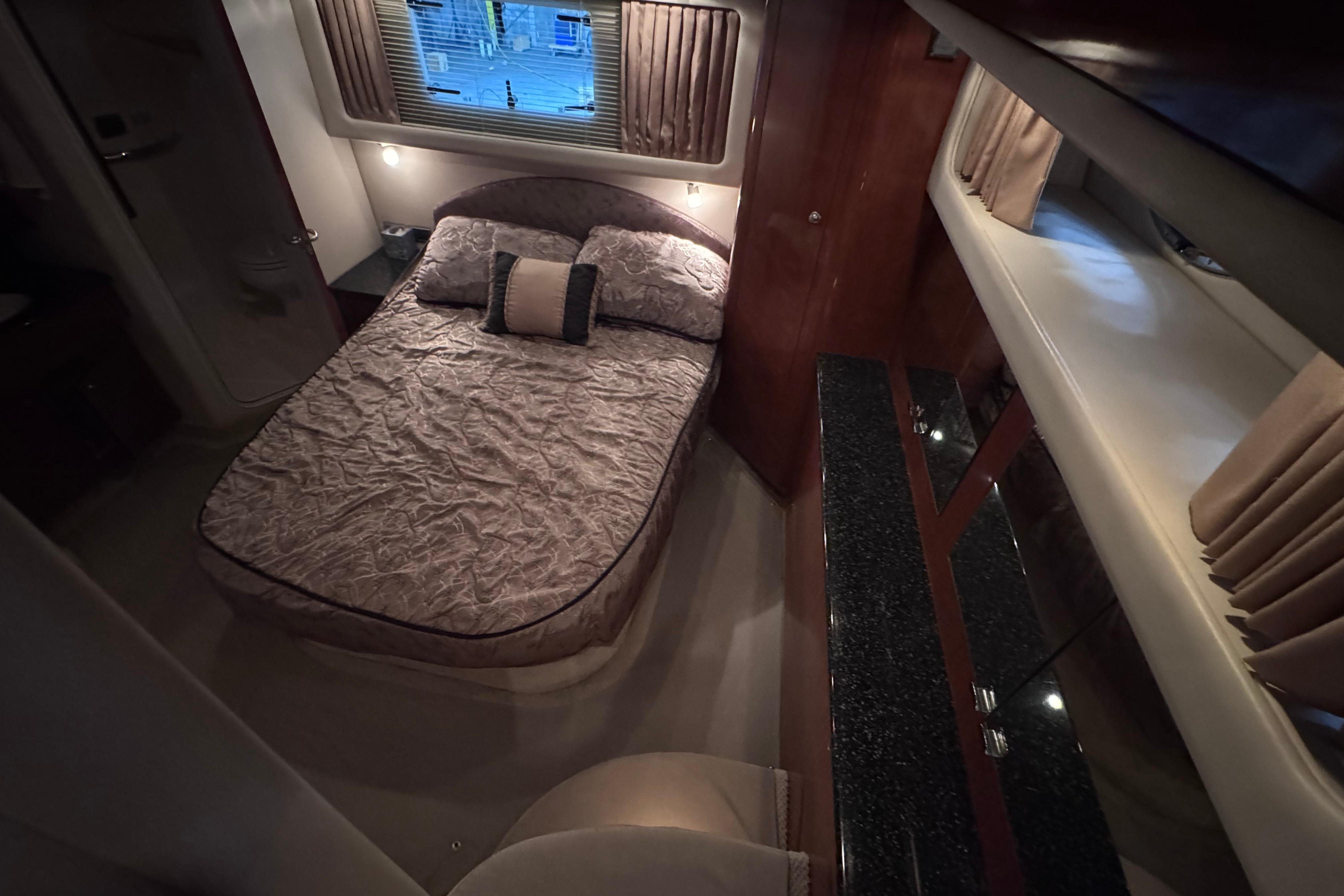 Luxurious bedroom interior of 2004 Sea Ray 390 Motor Yacht with elegant bedding and cabinetry.
