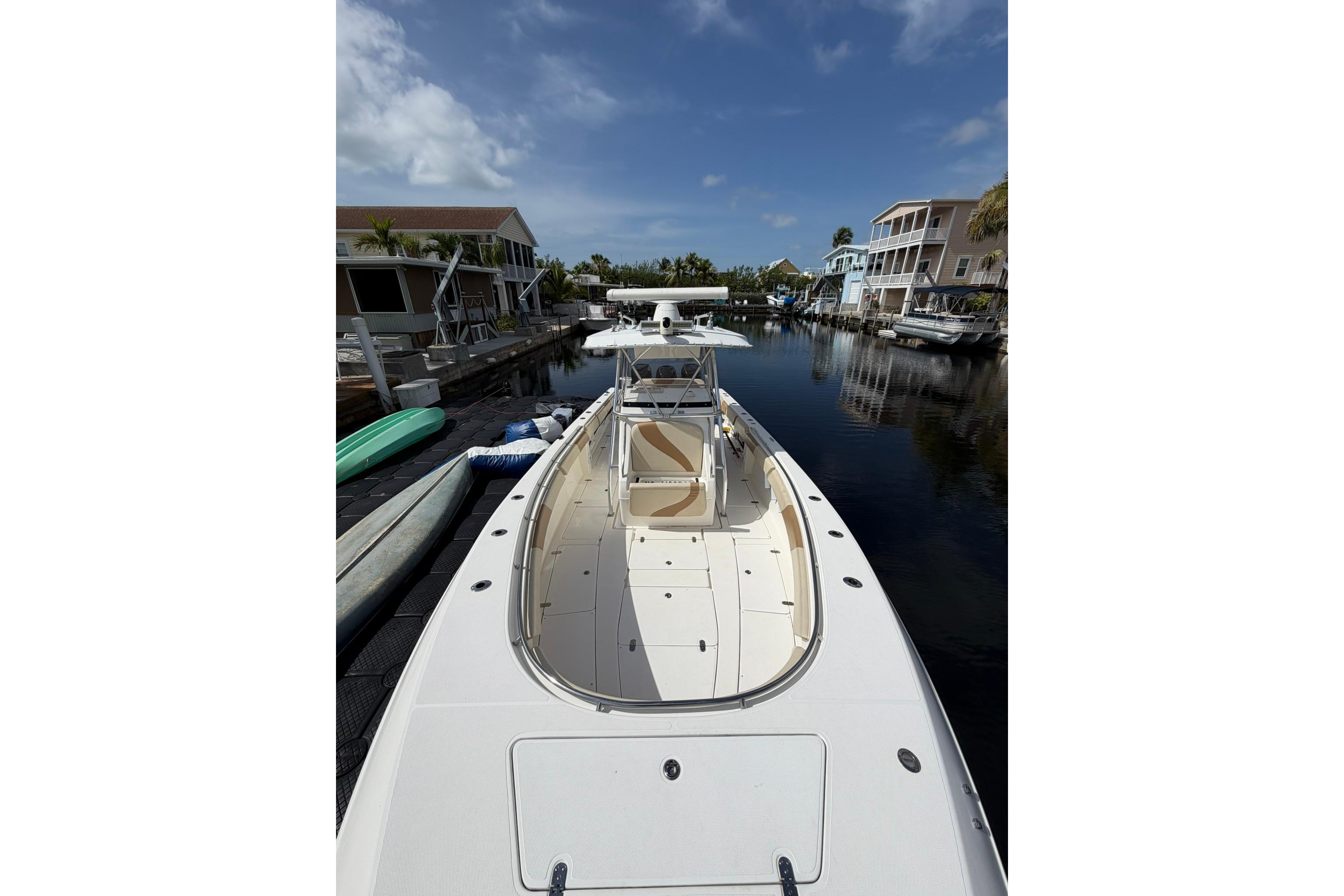 2007 Fountain 34 Center Console boat docked in a serene canal setting.