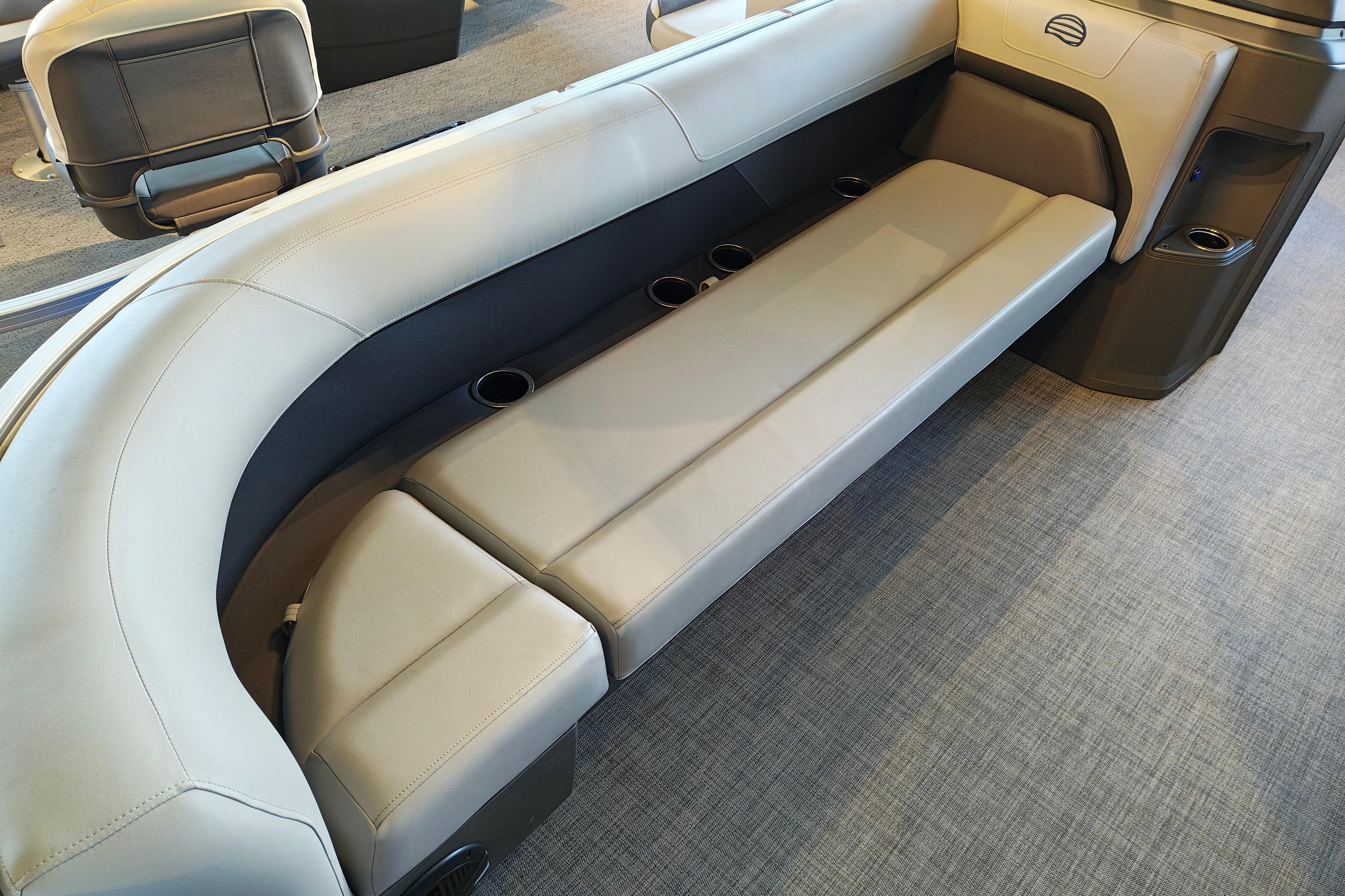 2026 Sun Tracker Party Barge 18 DLX interior seating with cup holders on a gray carpet.