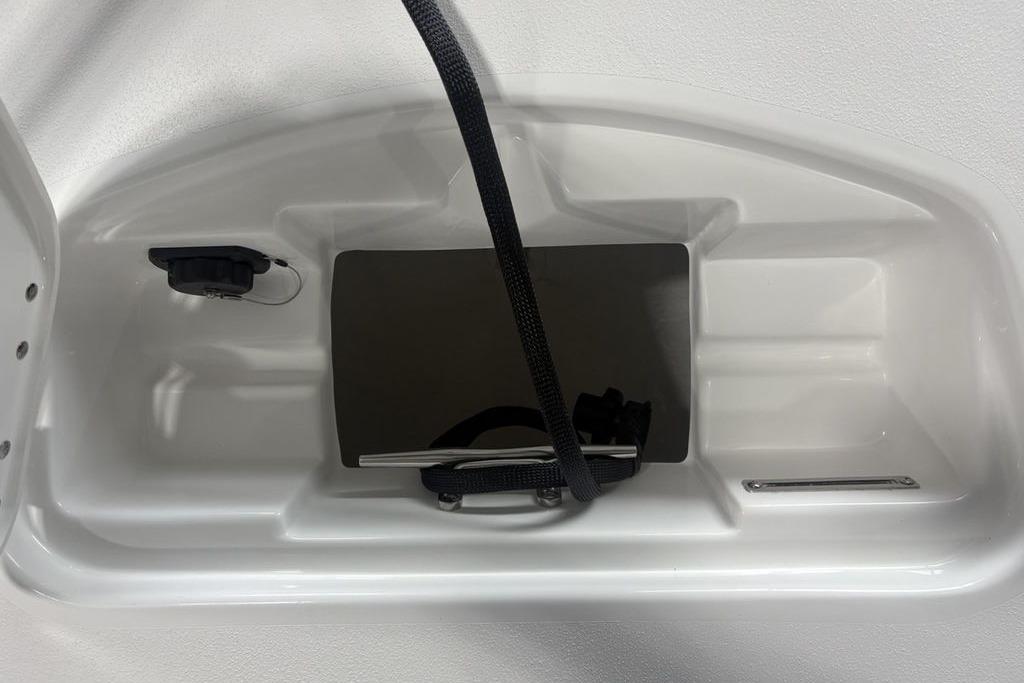 2026 Tidewater 2300 Carolina Bay storage compartment with black strap and plug socket.