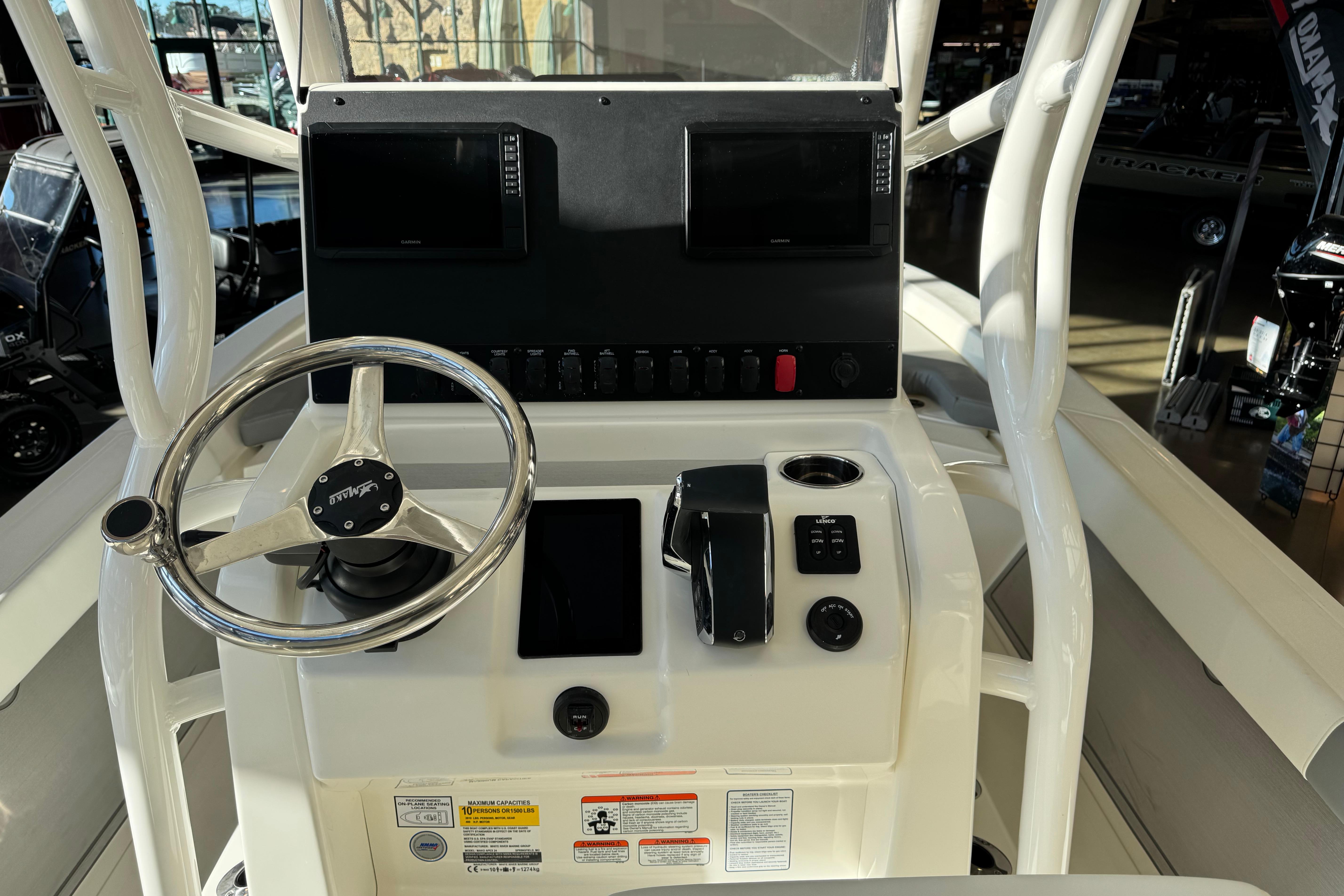 Control console of 2026 Mako 24 APEX boat with steering wheel and navigation displays.