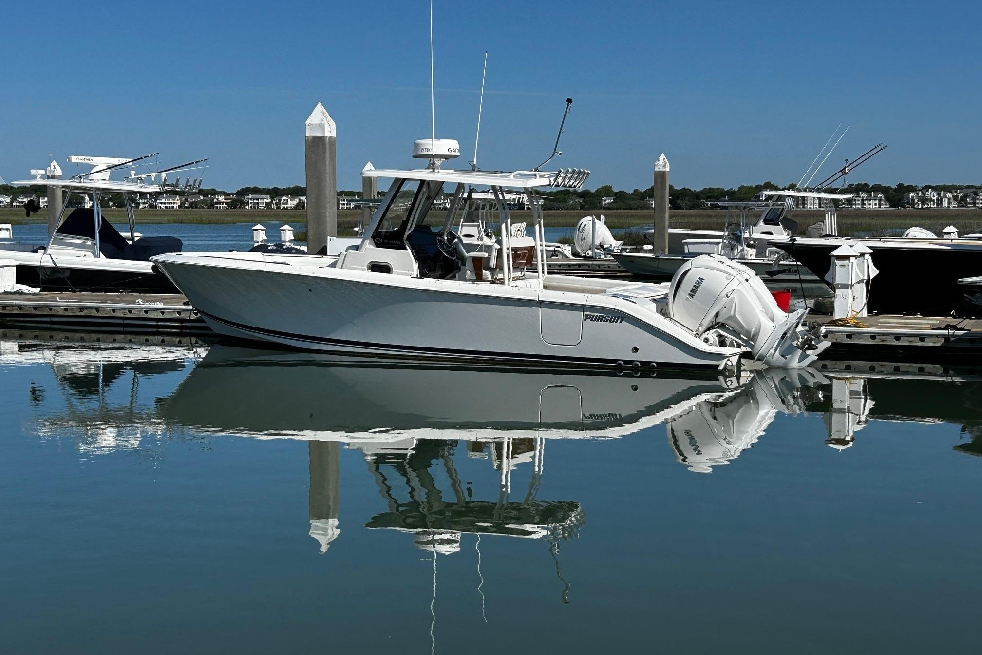 2024 Pursuit S 288 Sport boat docked in a serene marina setting.