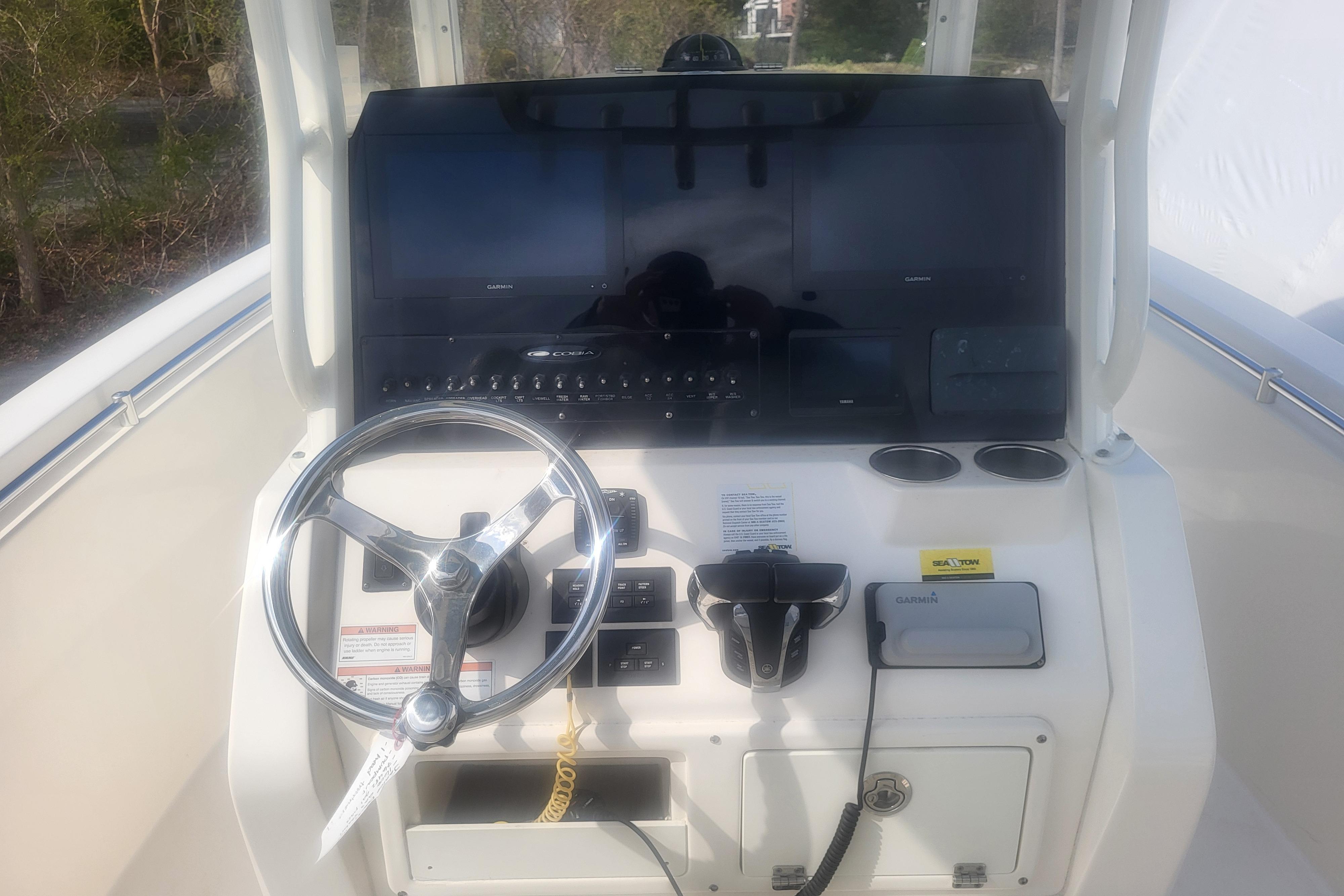 2022 Cobia 262 Center Console helm with steering wheel and navigation controls.
