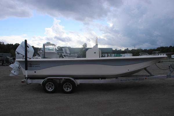 2025 Carolina Skiff 23 LS boat on trailer under cloudy sky.