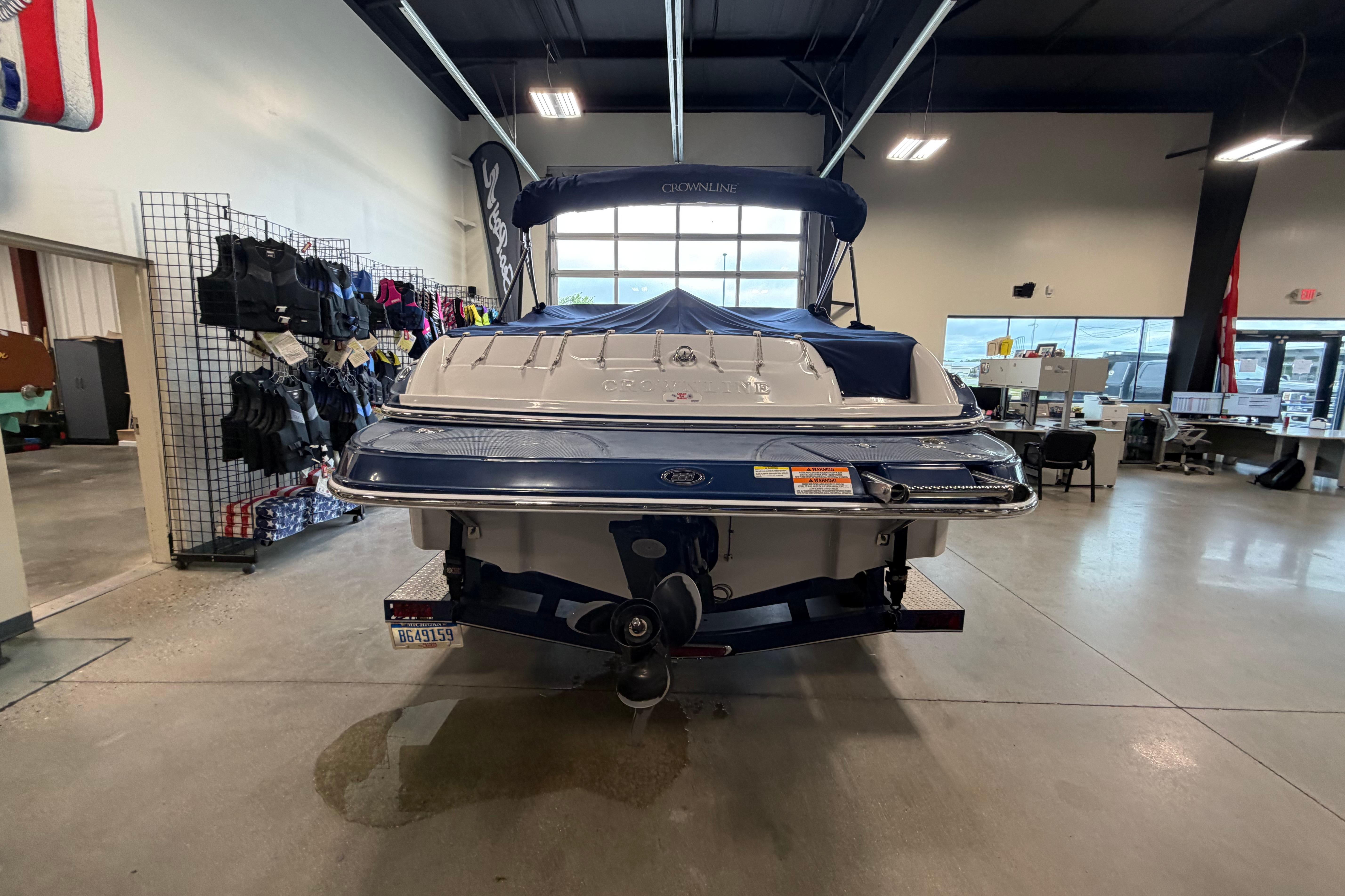 2008 Crownline 220 LS boat displayed indoors with life jackets on racks nearby.