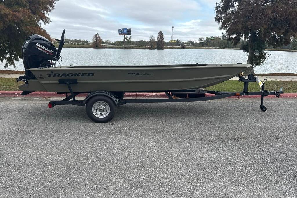 2026 Tracker Grizzly 1654 T Sportsman boat on trailer by a lake.