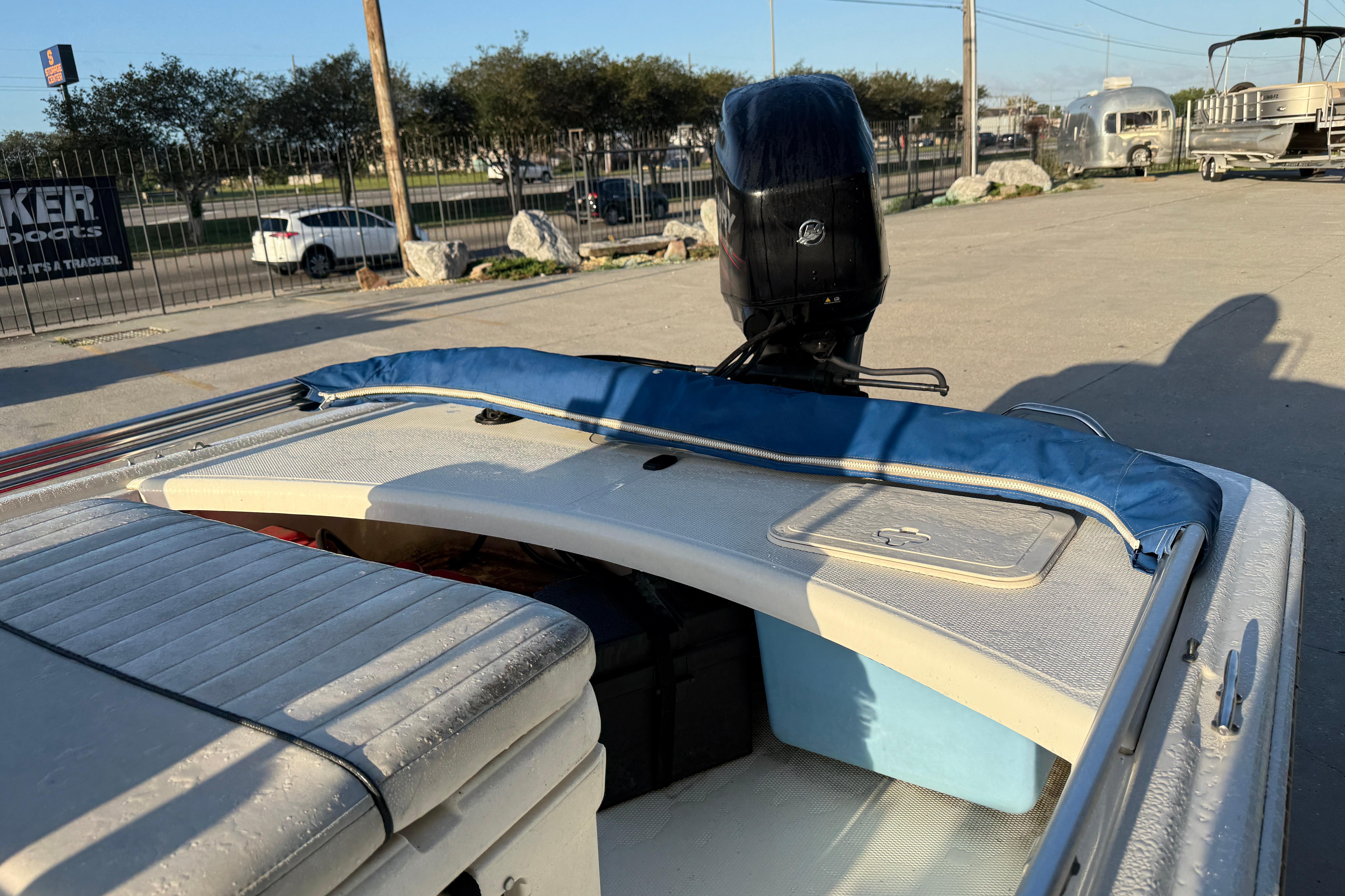 2017 Mako Pro Skiff 17 CC boat with motor, parked outdoors.
