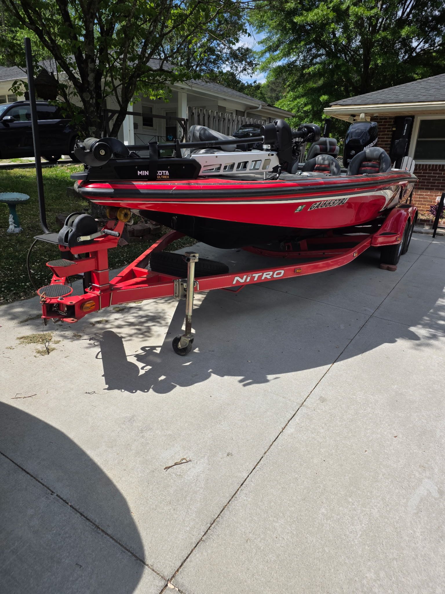 A red 2010 Nitro Z-8 boat on a trailer in a driveway.