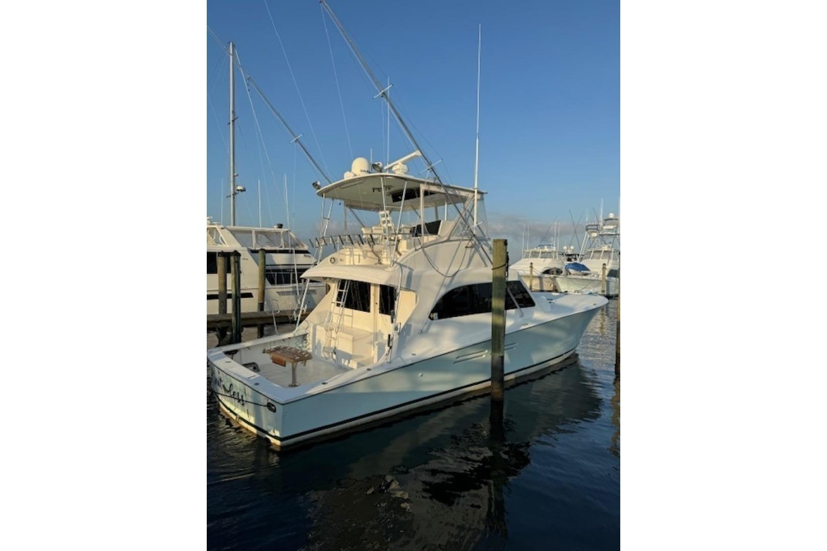 1998 Post 50 yacht docked at marina under clear blue sky.