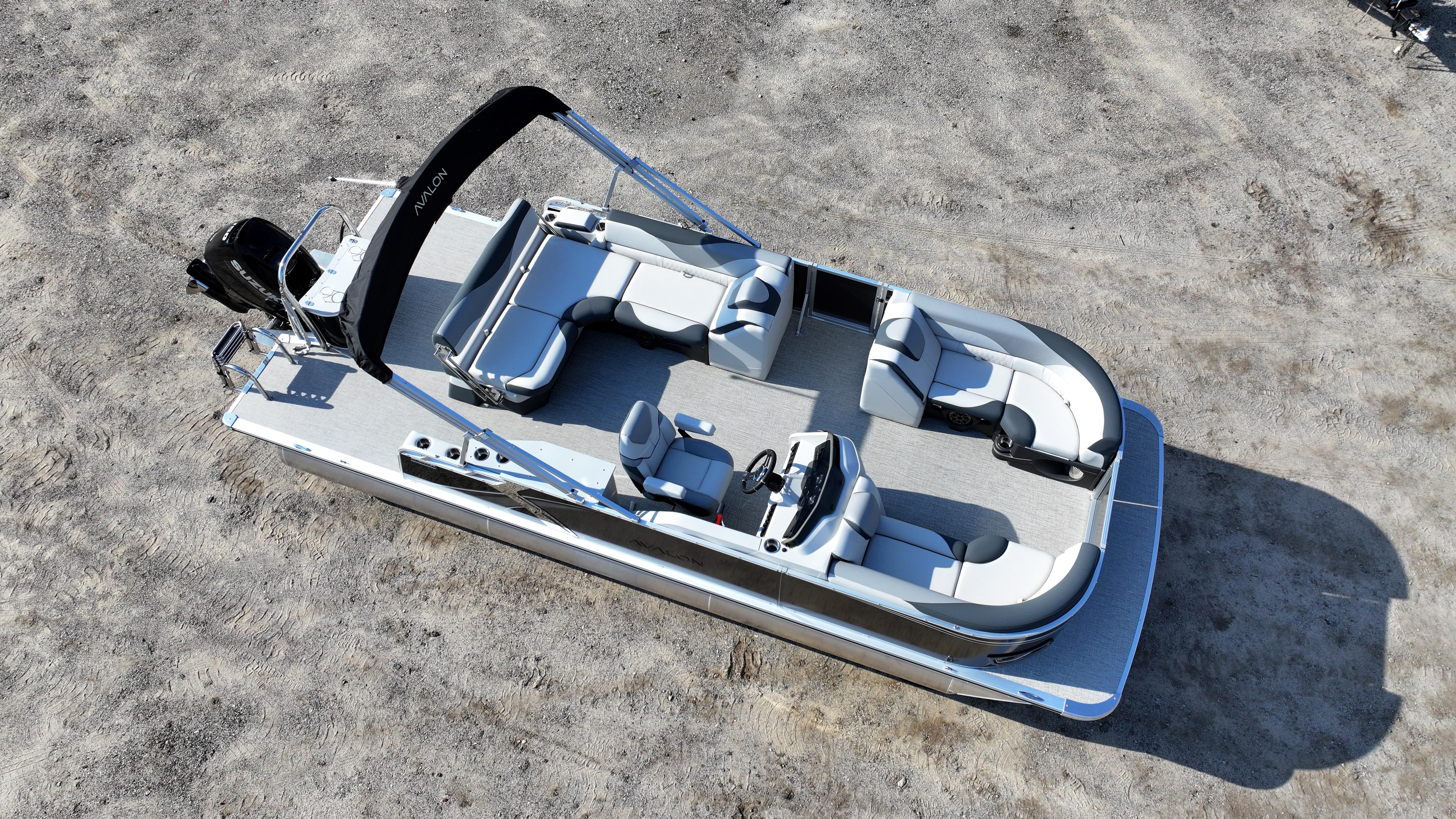 2025 Avalon LSZ Cruise Rear Bench pontoon boat on sandy terrain, featuring spacious seating and sleek design.