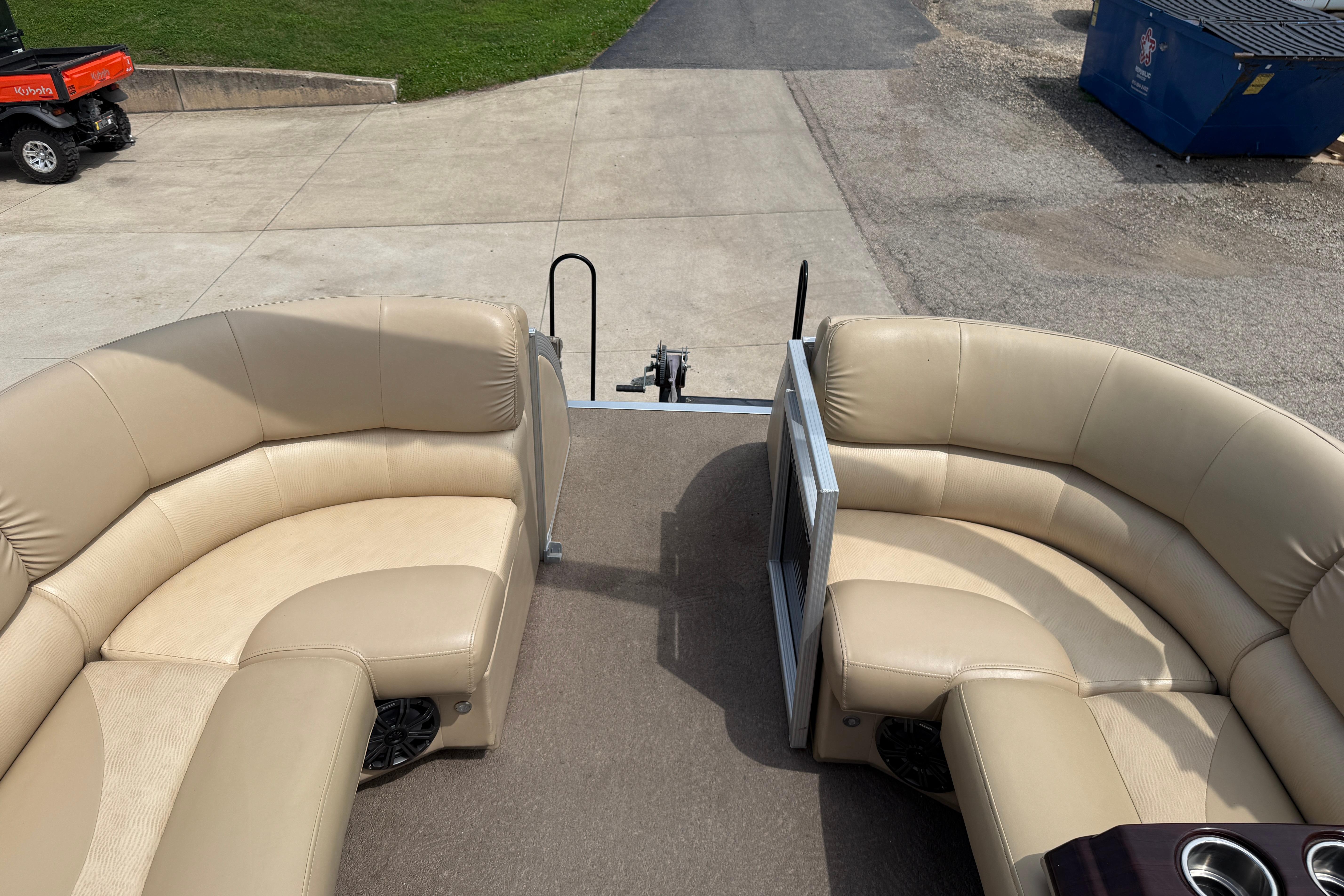 2011 Bennington 2575QCW I/O boat with beige seating, docked on concrete.