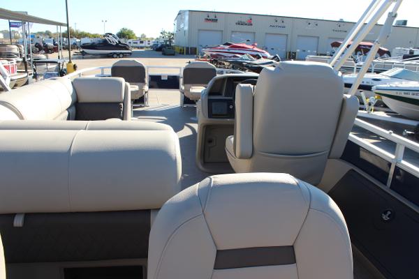 2025 Sun Tracker Fishin' Barge 22 DLX interior with beige seating and helm.